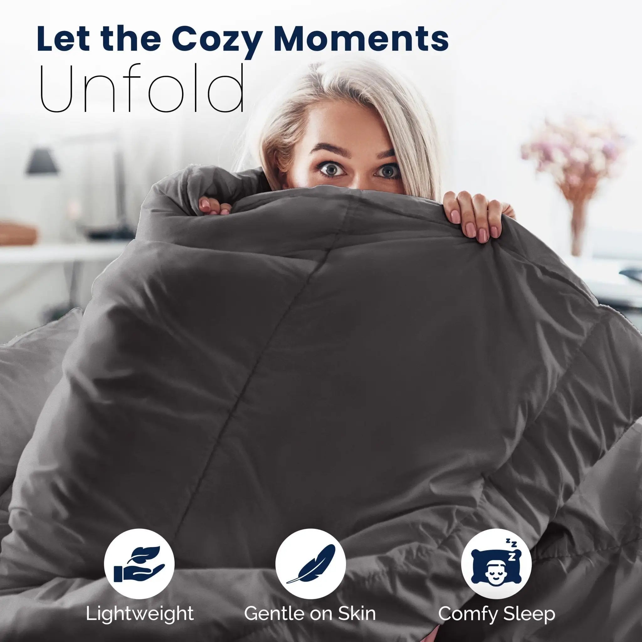 Woman hugging a large graphite comforter with text 'Let the Cozy Moments Unfold' and icons for lightweight, gentle on skin, and comfy sleep.