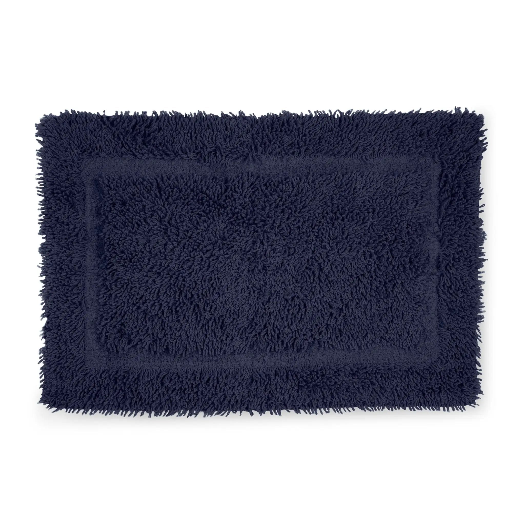 A rectangular navy blue bath rug with a shaggy, high-pile texture and fringed edges, shown flat against a plain white background.
