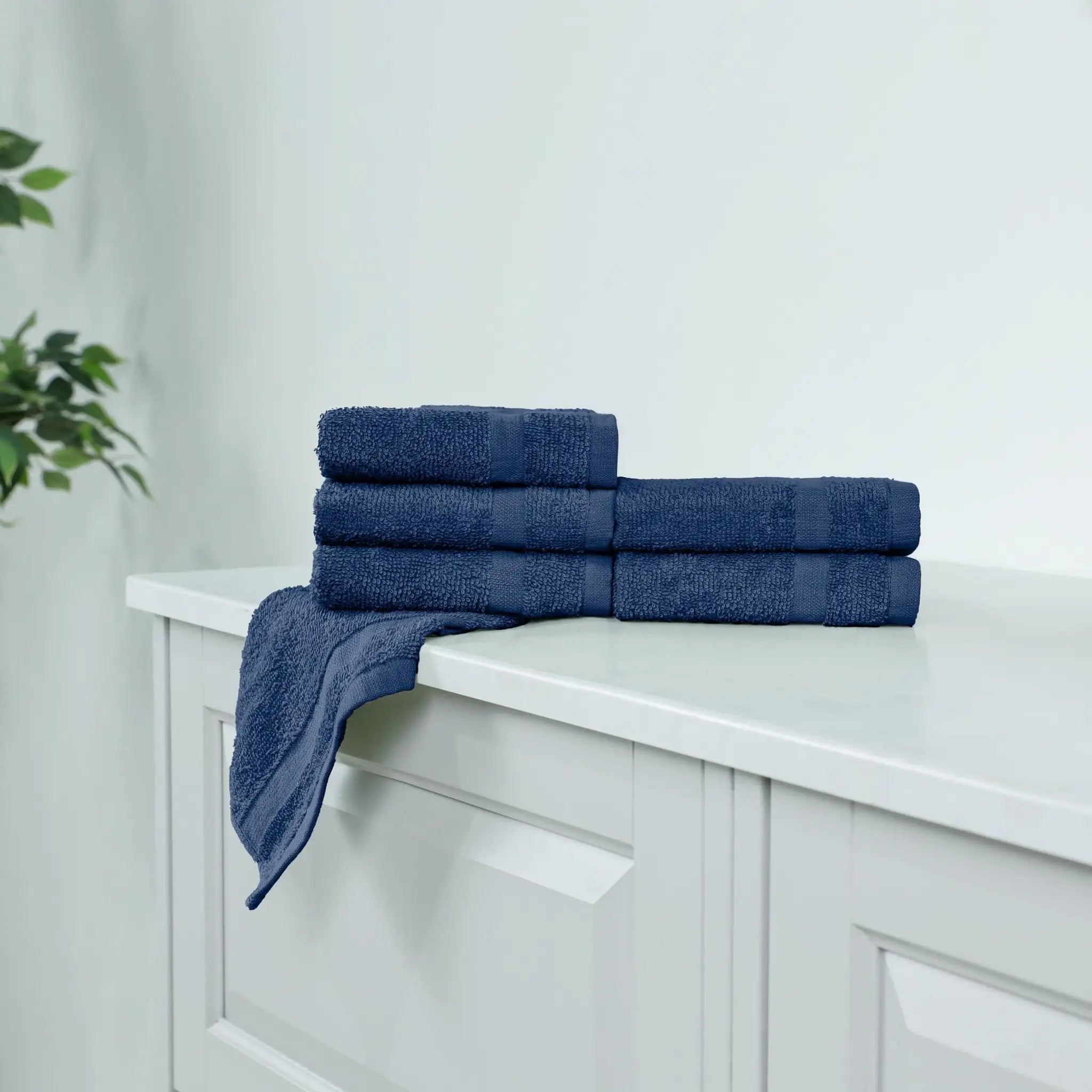 Stack of navy washcloths on a white cabinet.