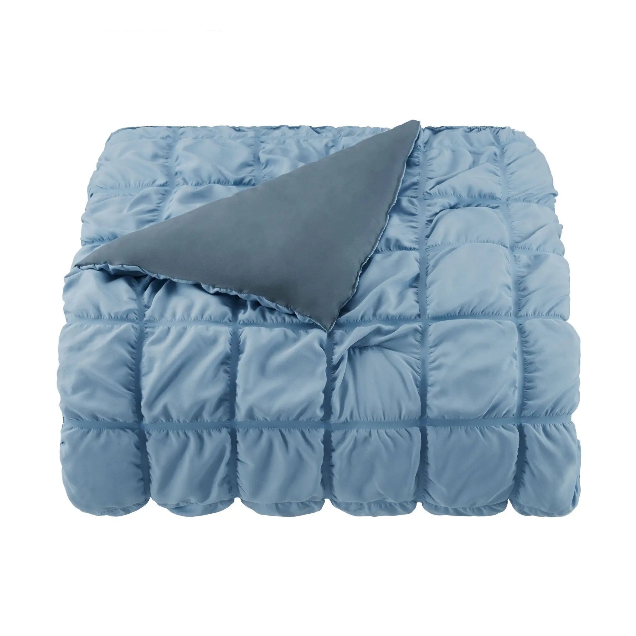 Blue quilted comforter on a white background
