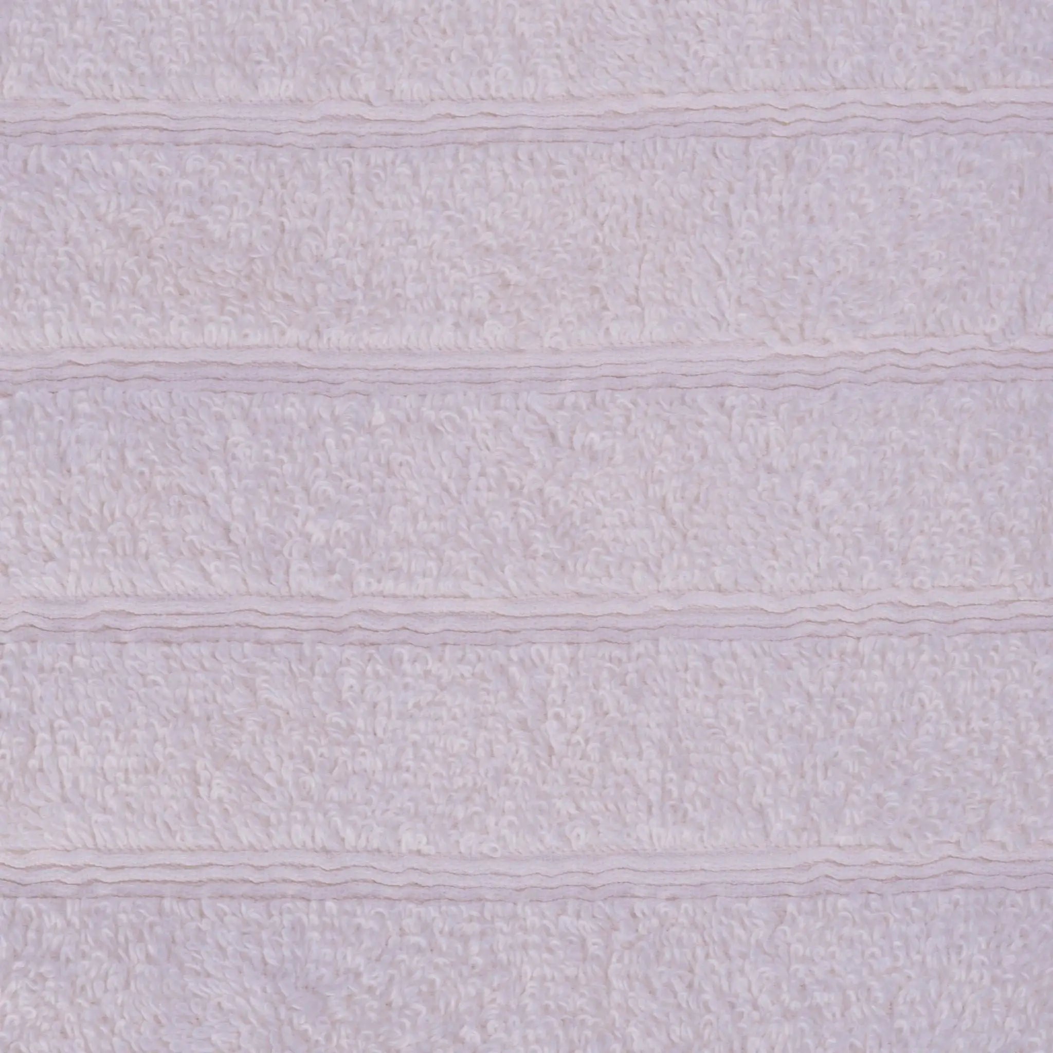 A close-up of an ivory textured bath towel with horizontal ribbed stripes.