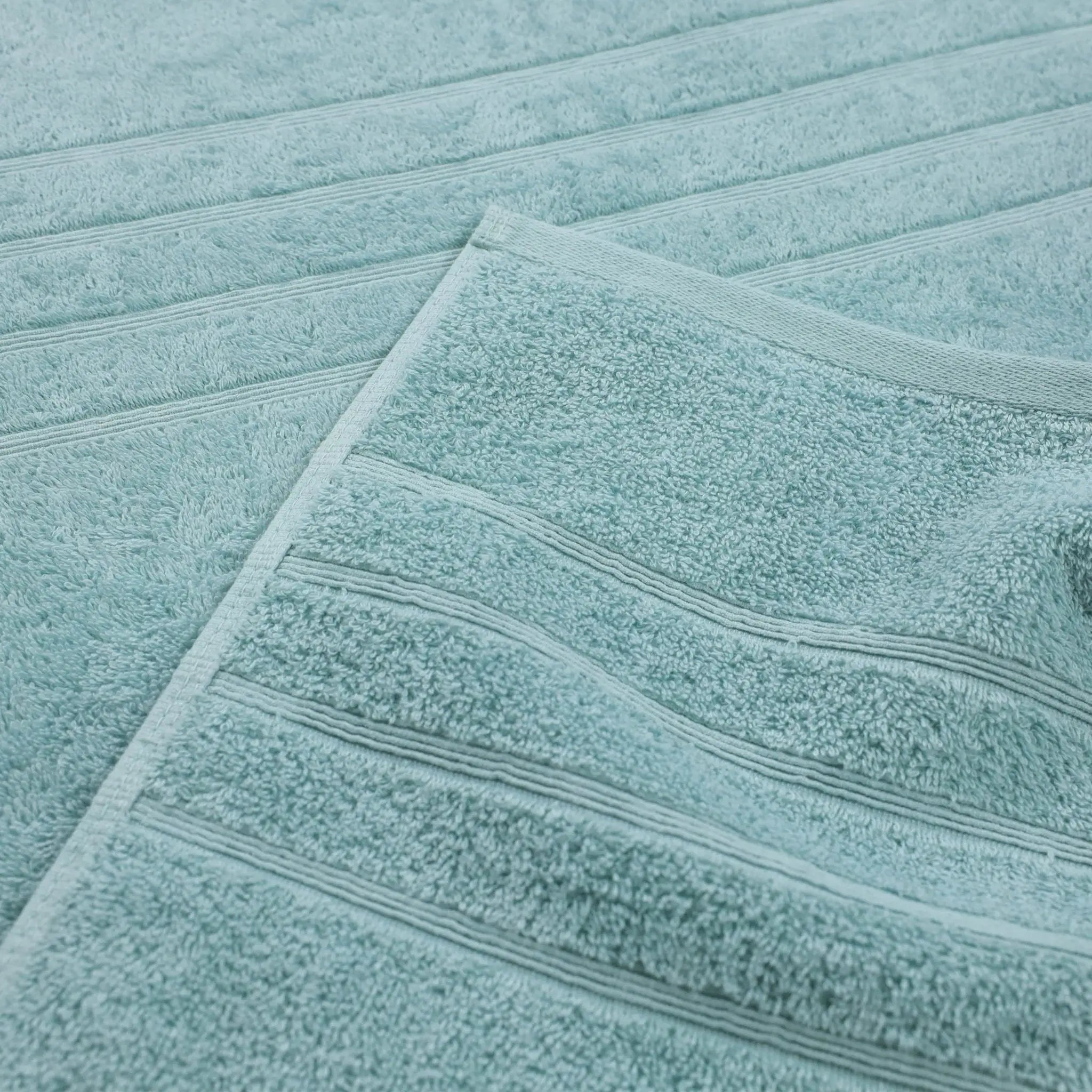 A close-up of a mineral bath towel with horizontal ribbed stripes, layered over another matching towel.
