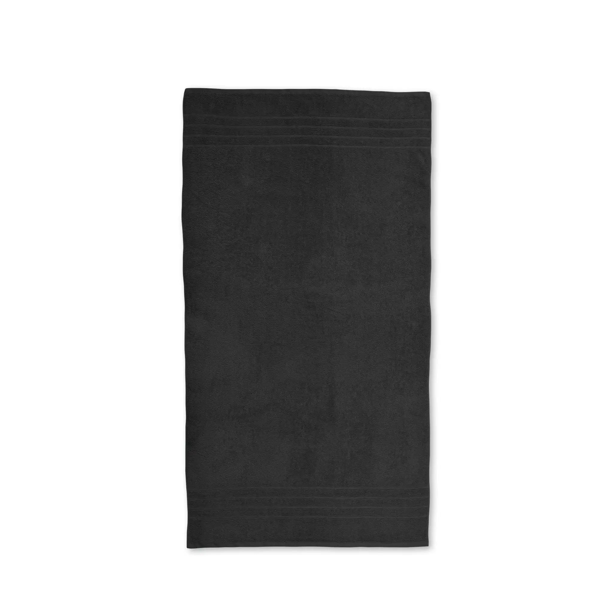 Black bath towel laid flat on a white background