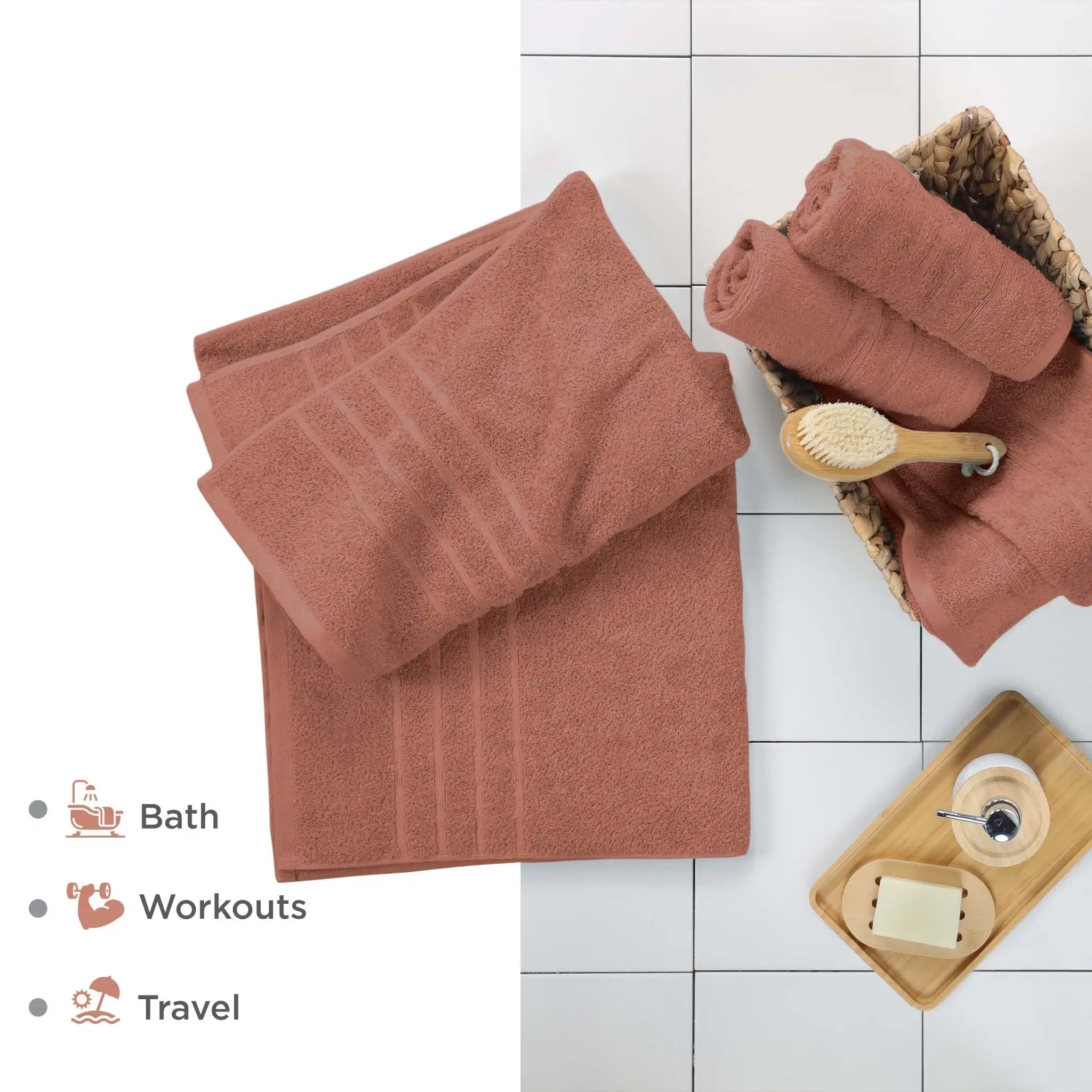 Terracotta bath sheets on a white tiled floor with a brush and soap dish.