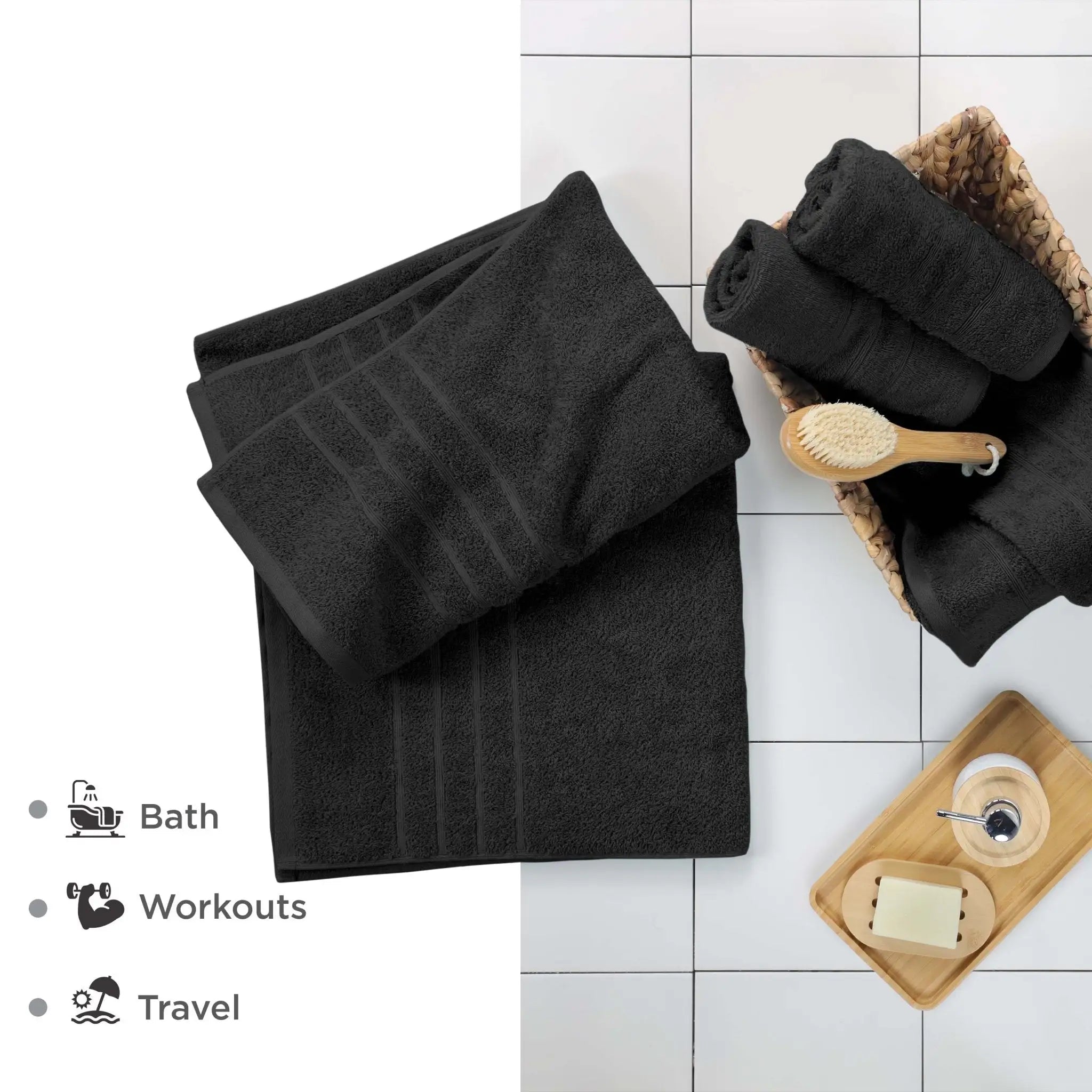 Black bath sheets and accessories on a white tiled floor