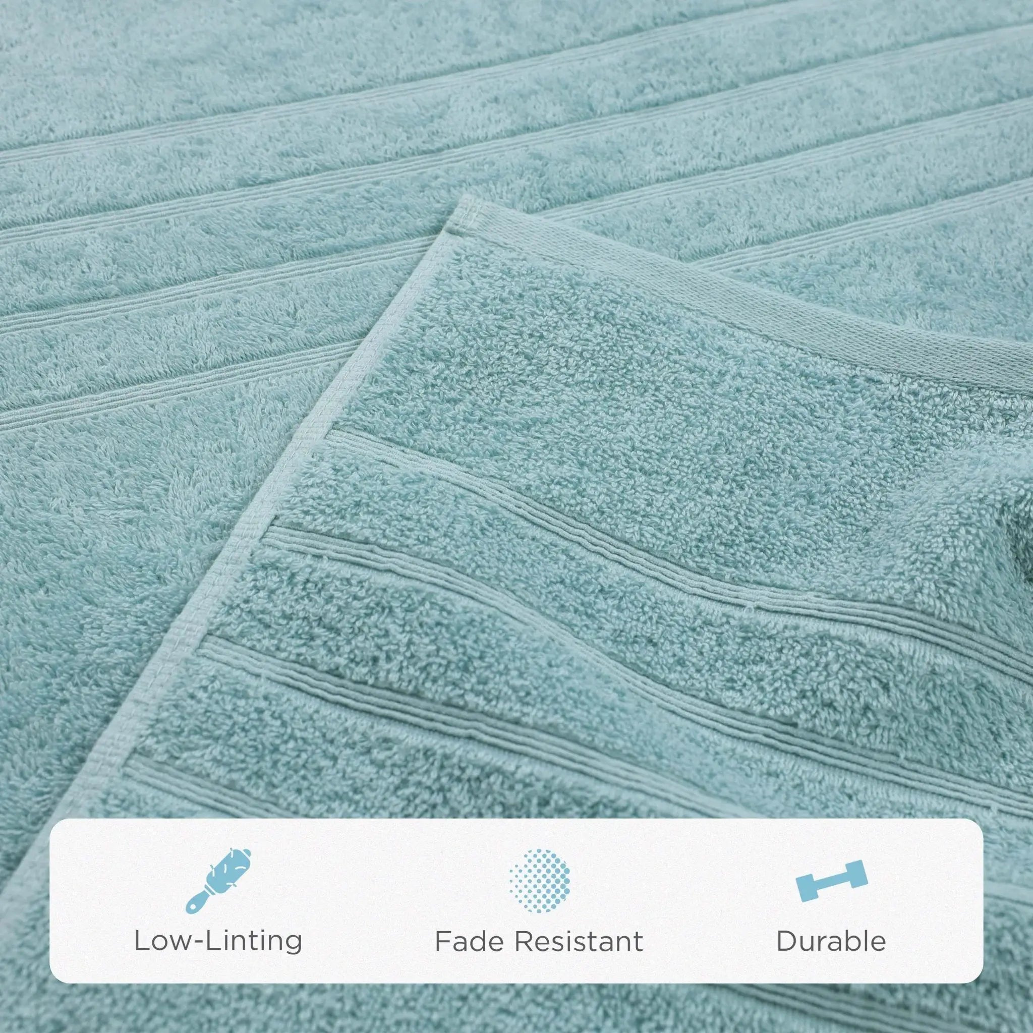 A close-up of a mineral-colored bath sheet with horizontal ribbed stripes, showing its soft terry texture. A white banner at the bottom features icons and the text 'Low-Linting', 'Fade Resistant', and 'Durable'.