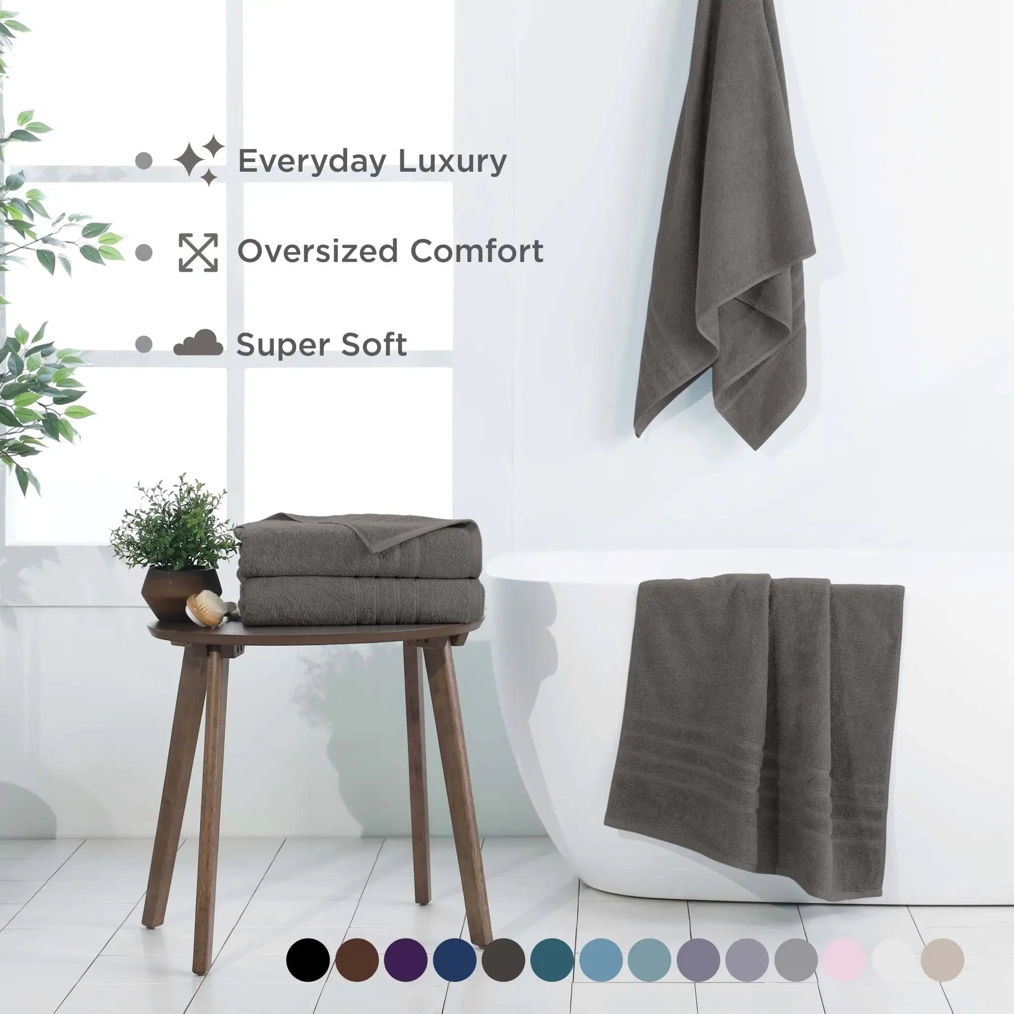 A set of dark gray bath sheets shown in a bright bathroom setting with feature text and a color swatch circle row at the bottom.