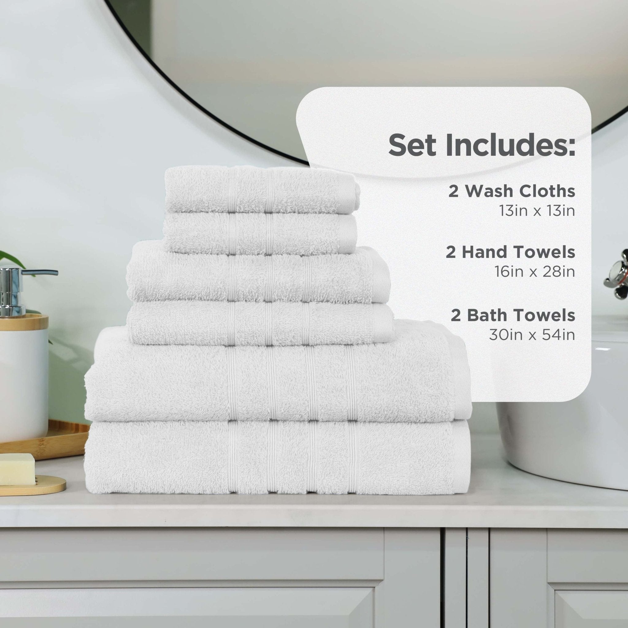 Set of white towels including wash cloths, hand towels, and bath towels on a bathroom counter.