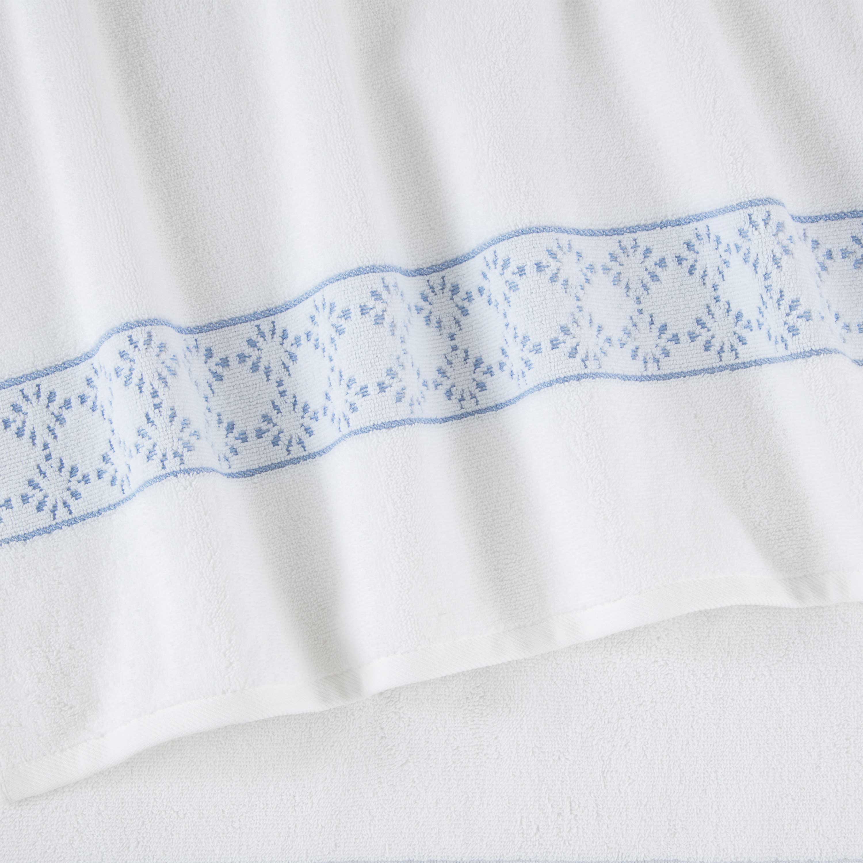 White towel with a light blue decorative band featuring a floral pattern.