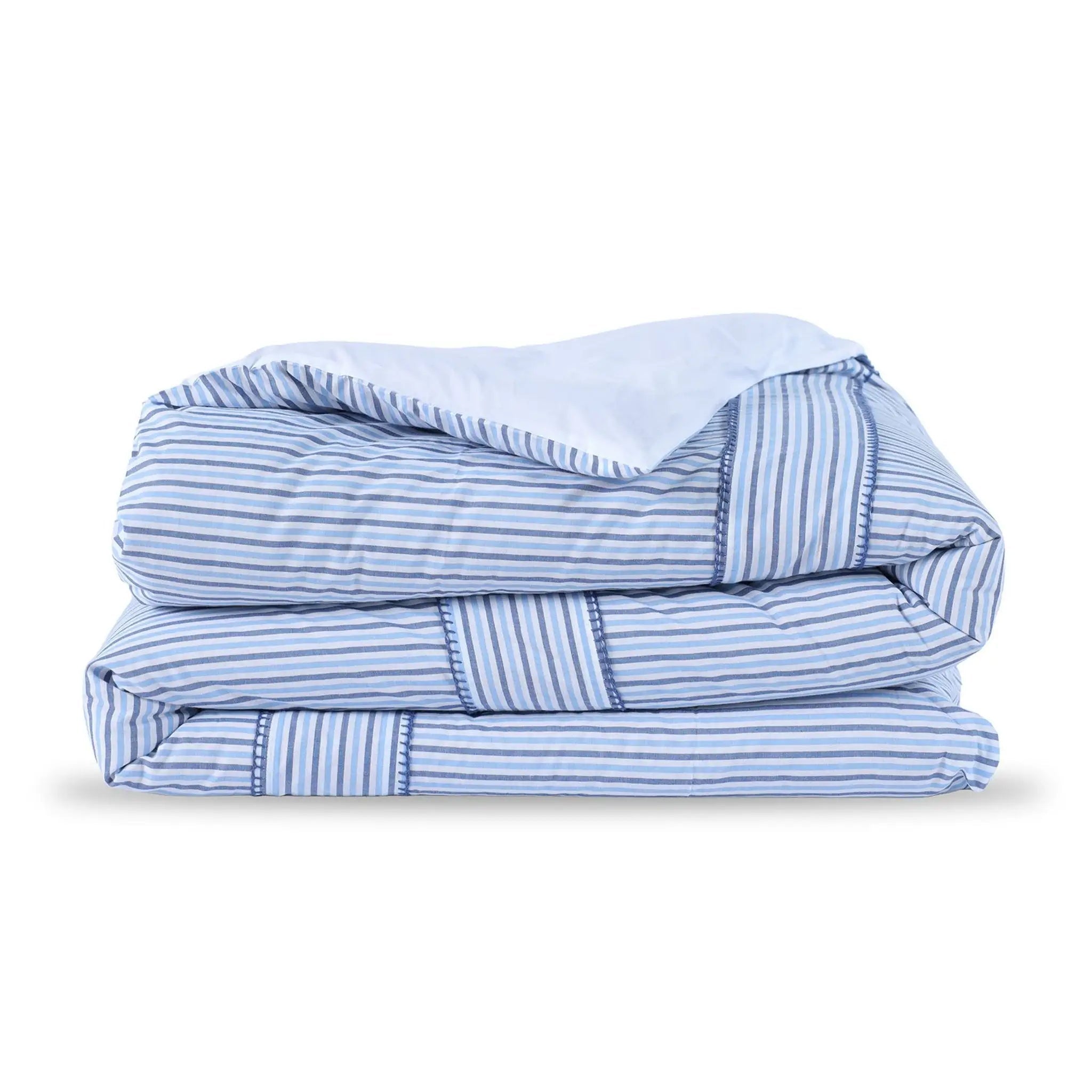 A folded comforter, featuring a light blue and white stripe pattern with solid light blue borders and a solid light blue reverse side, shown on a clean white background.