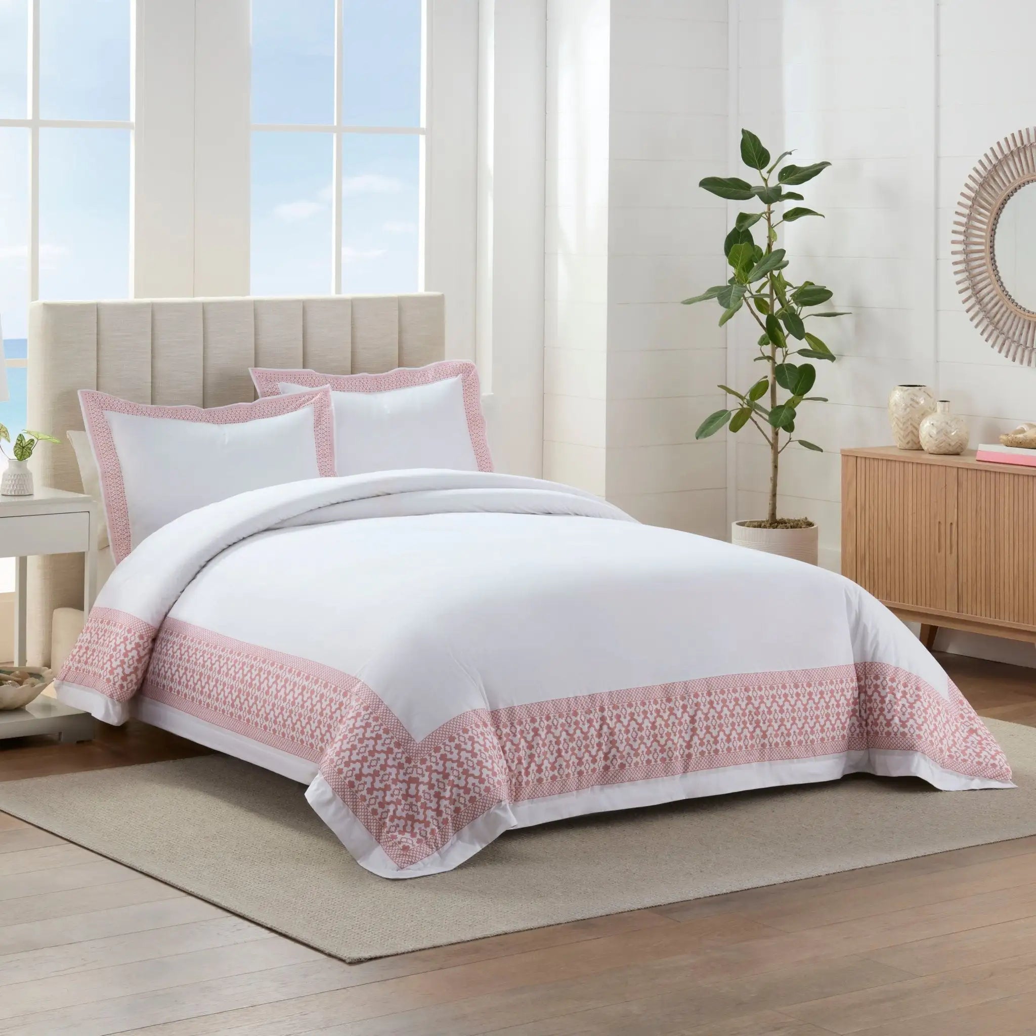 Bedroom with white comforter set and pink accents.