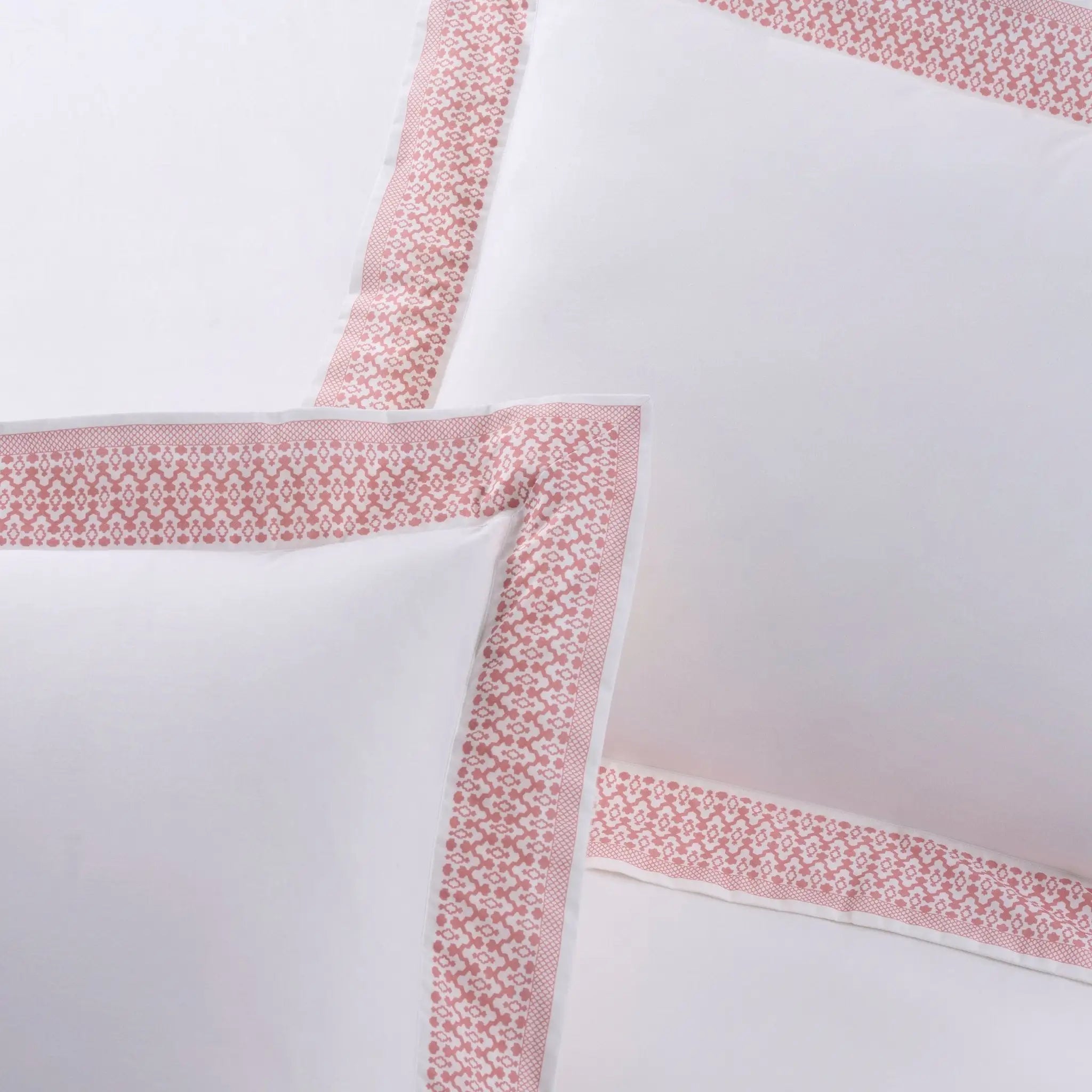 White pillow sham with pink borders.