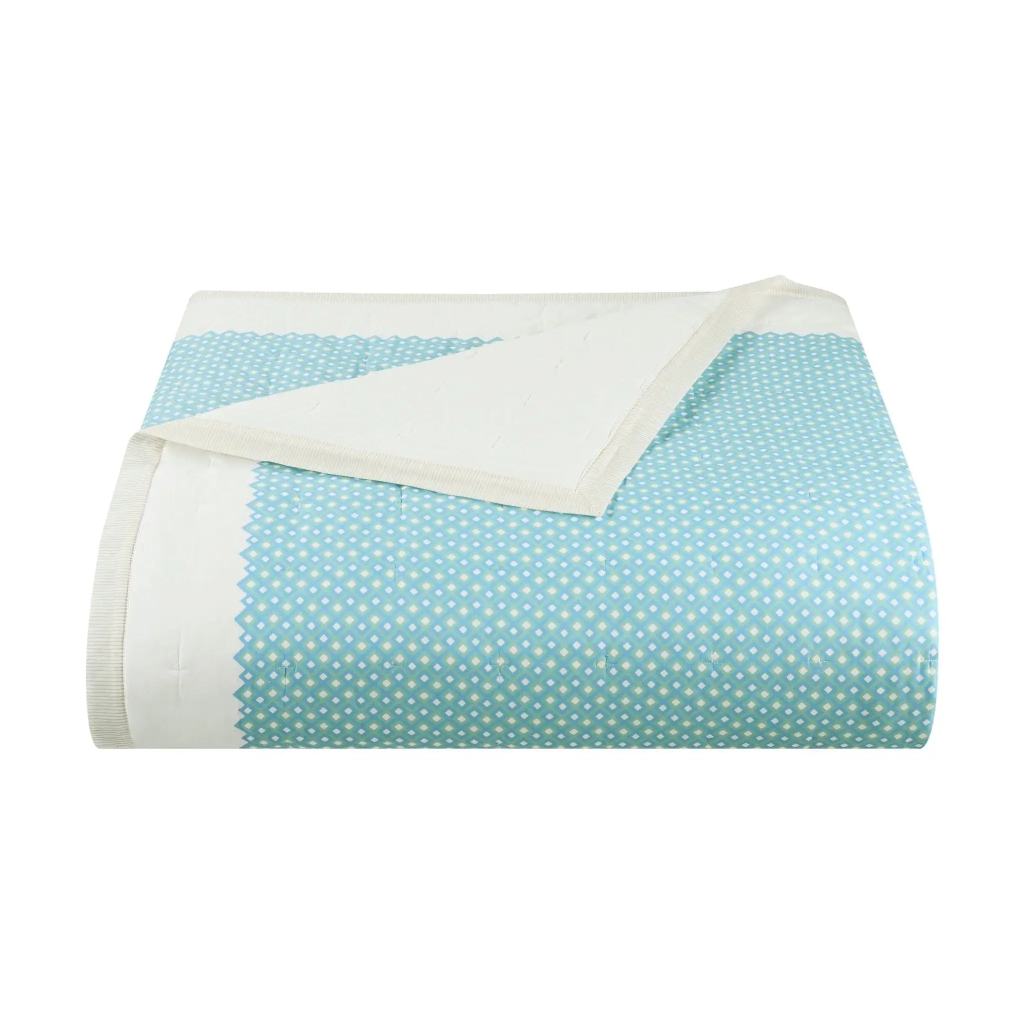 A folded light blue fabric quilt with small white polka dots and a solid white reverse side, shown on a plain white background.