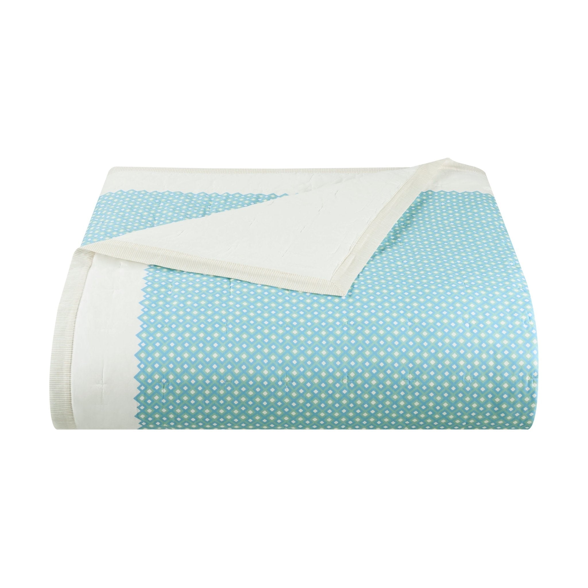 Folded quilt with blue and white polka dot pattern on a white background