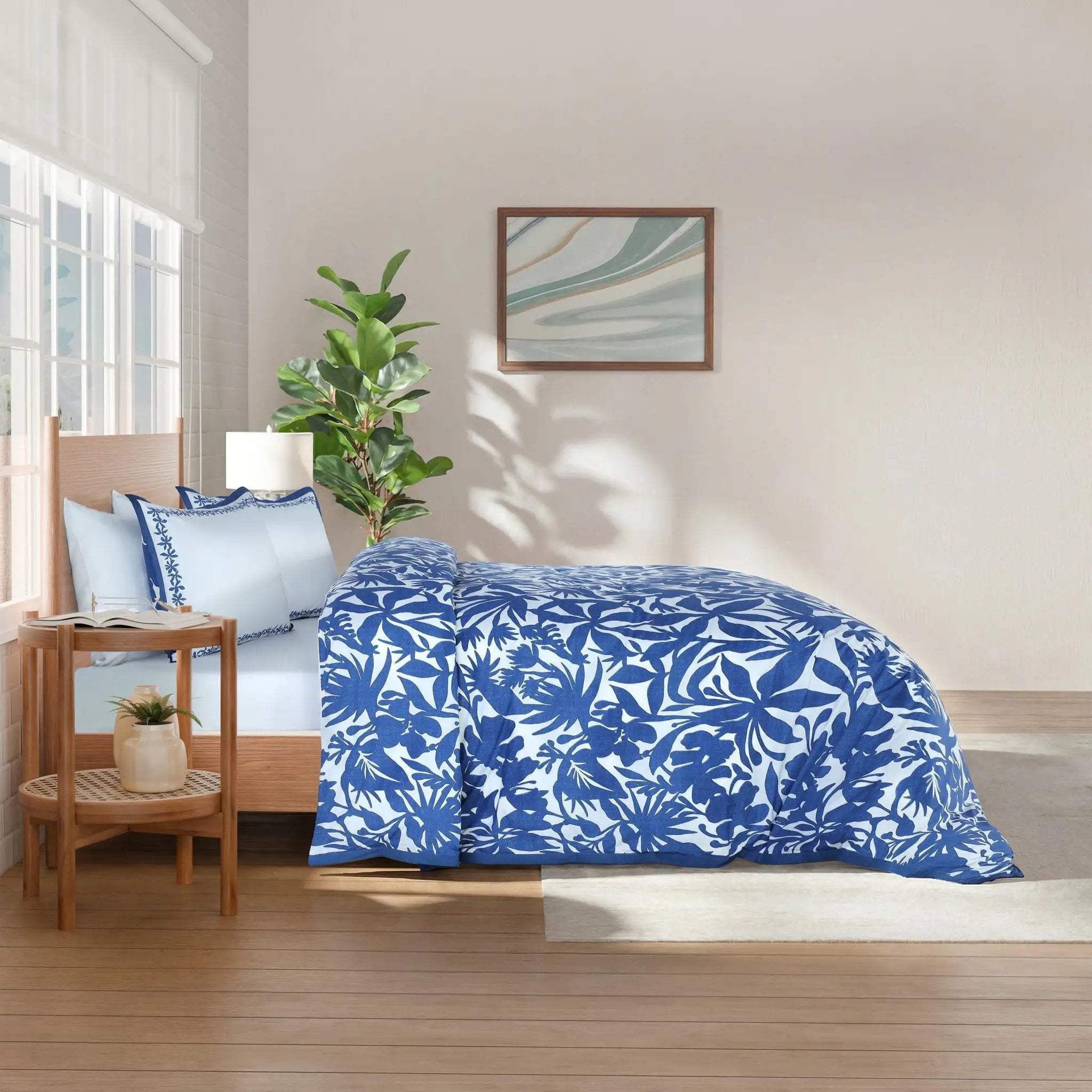 Bedroom with blue floral comforter and pillow euros.