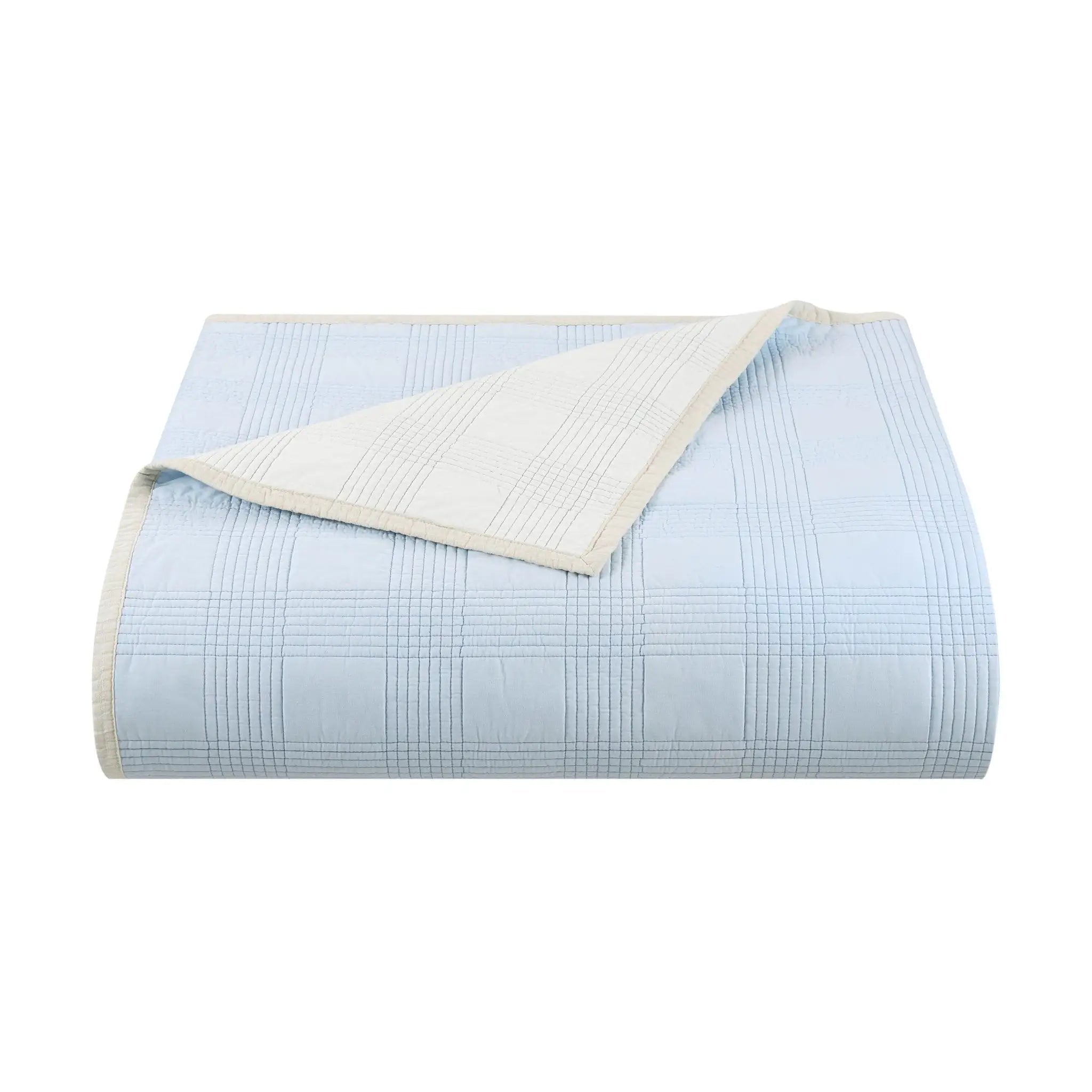 Light blue quilt with white checkered pattern on a white background