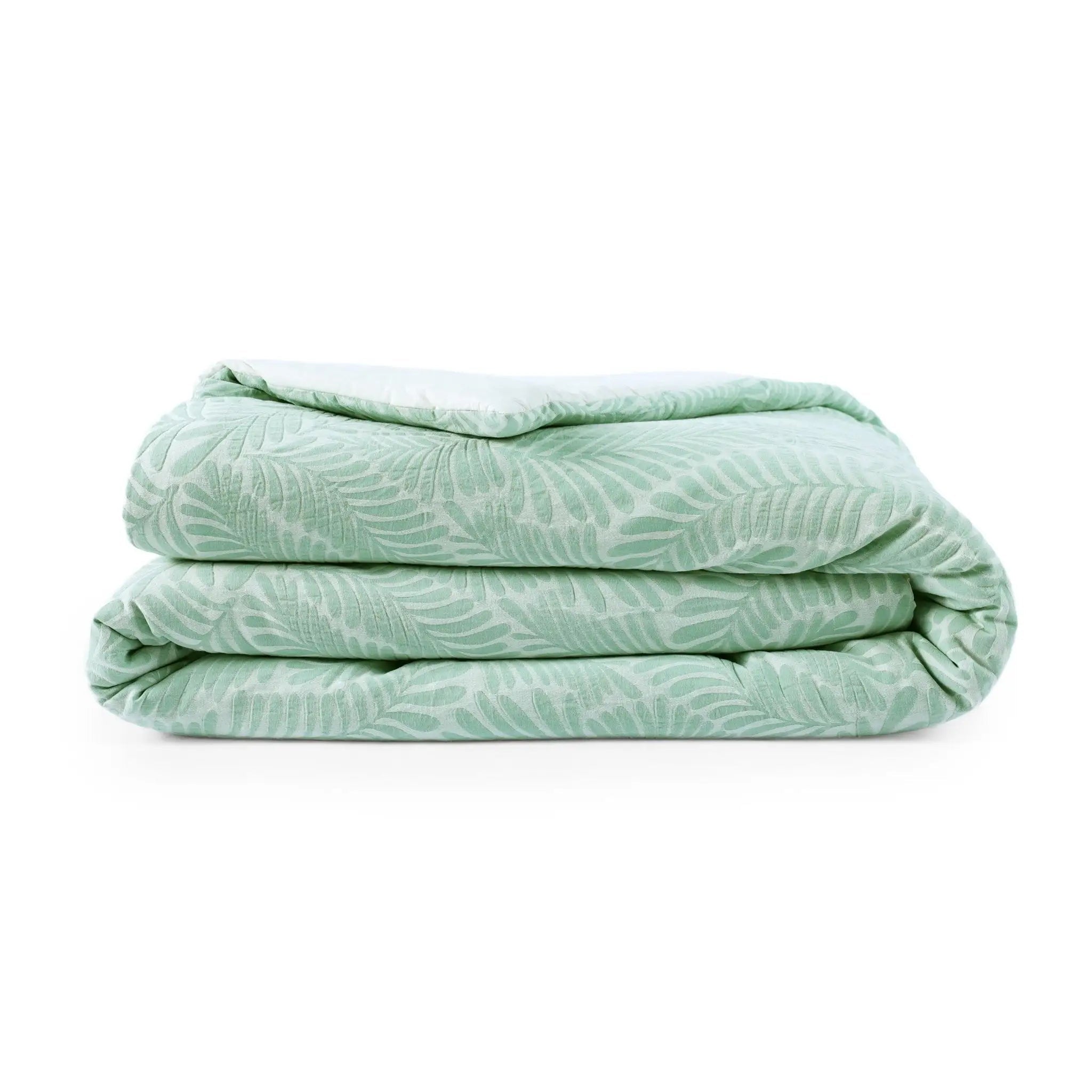 Folded light green comforter with a subtle pattern on a white background