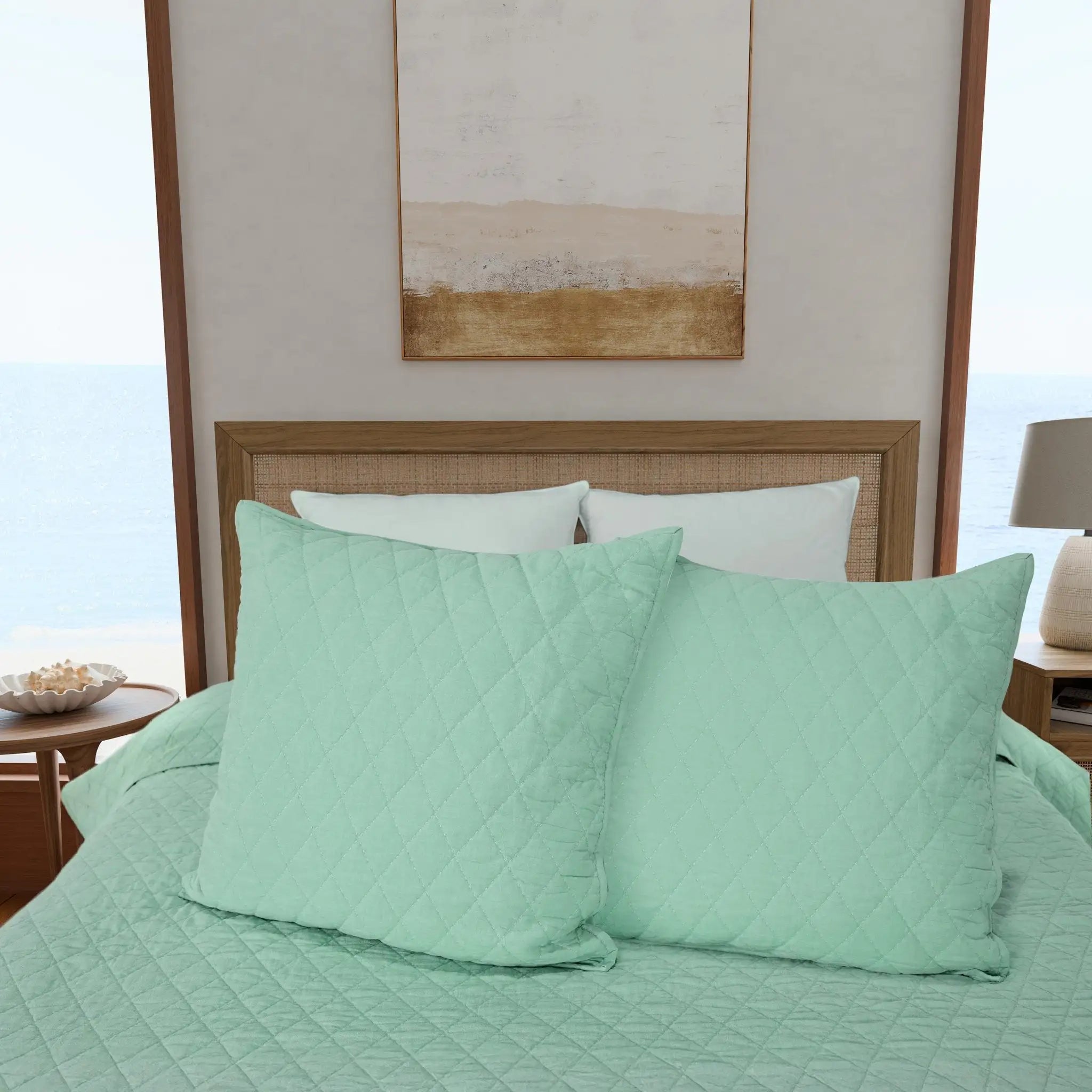 Green quilted euros on a bed.