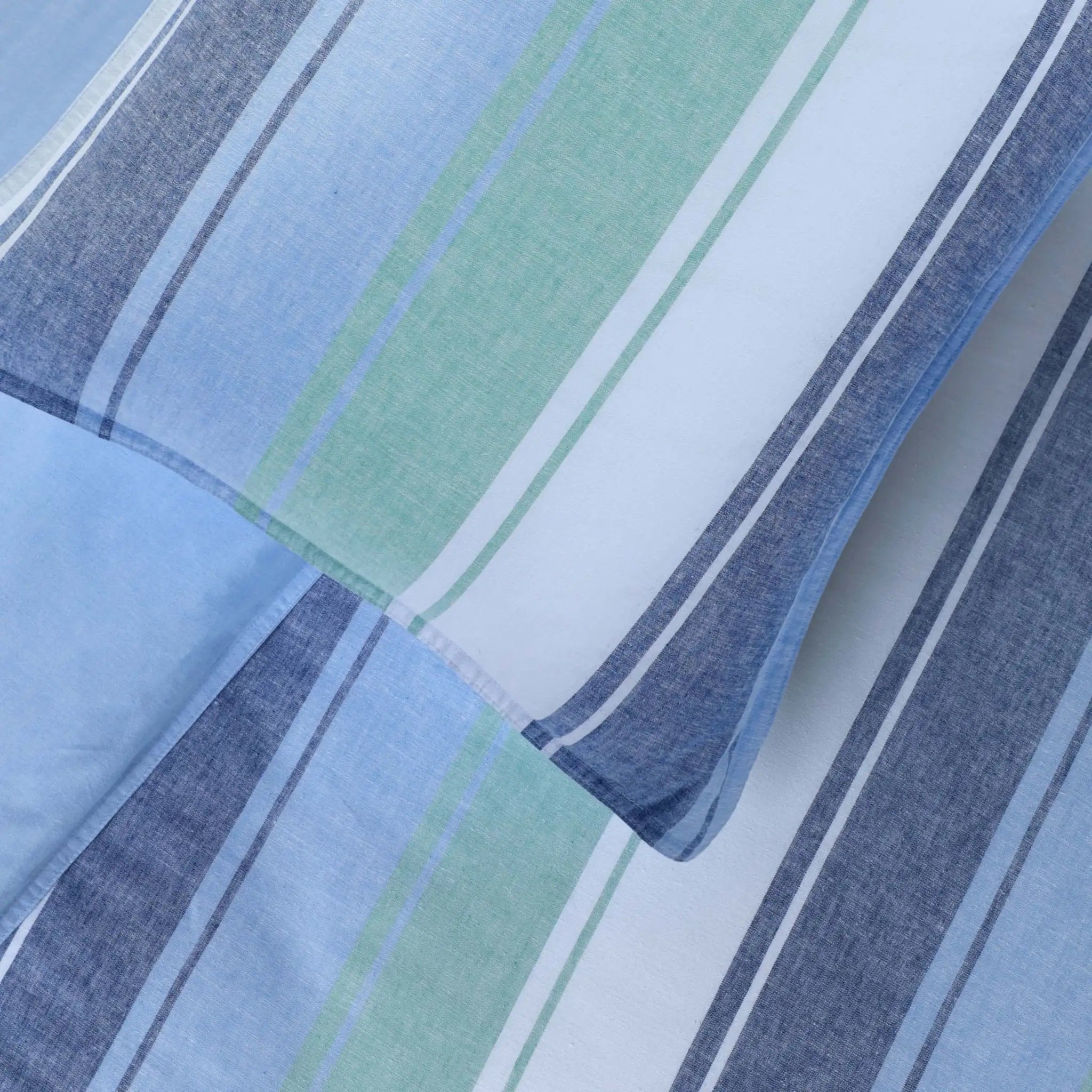 Close-up of fabric with blue, green, and white striped pattern
