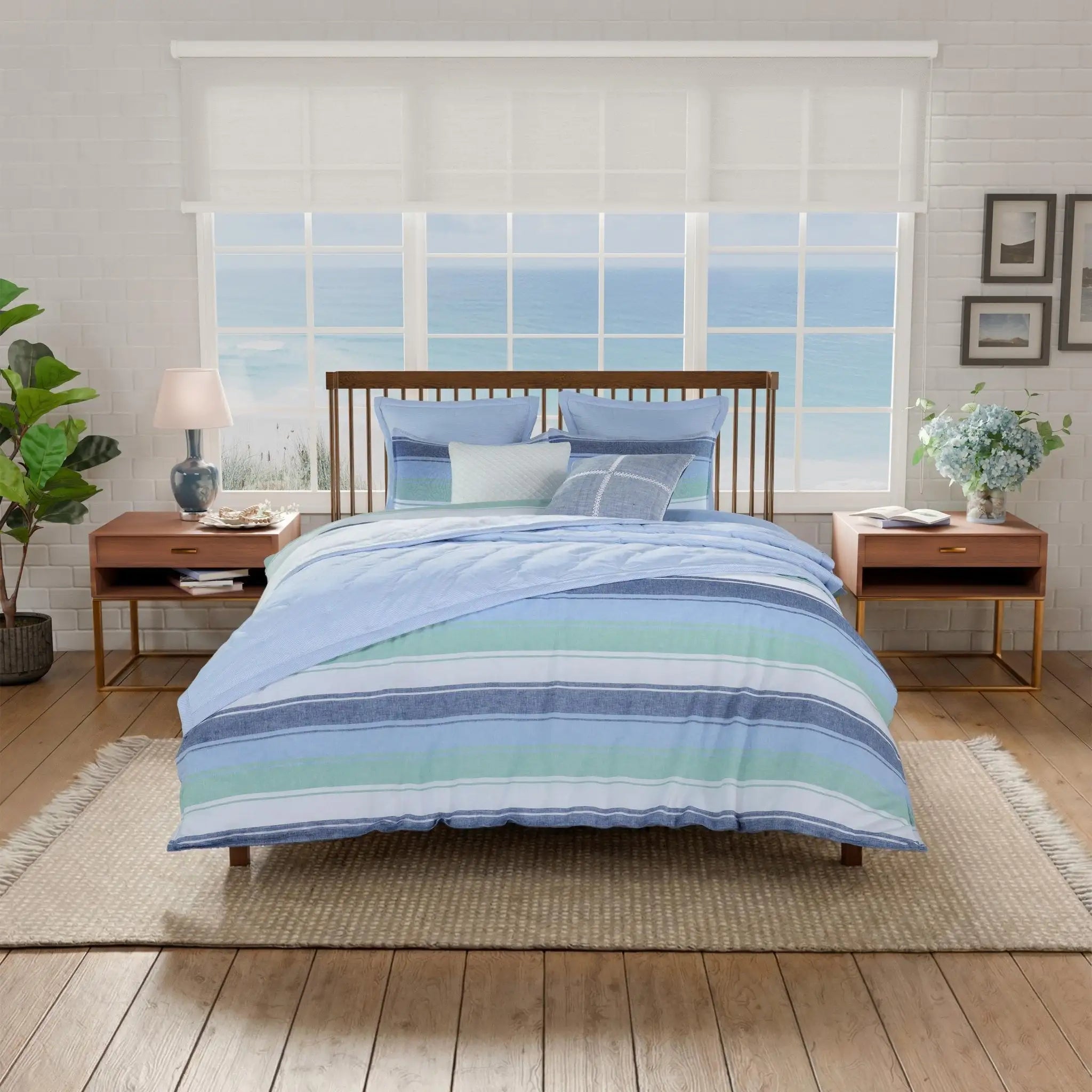 Bedroom with a bed featuring blue and green striped comforter set.