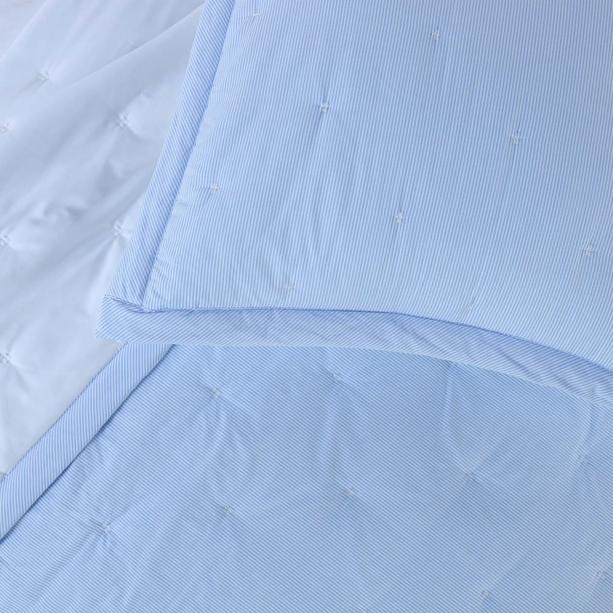 A close-up of a light blue quilt bedding set.