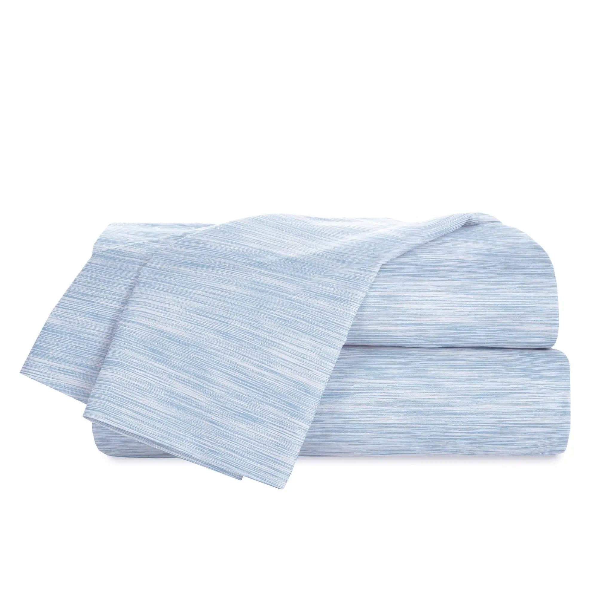 Stack of light blue striped bed sheets on a white background