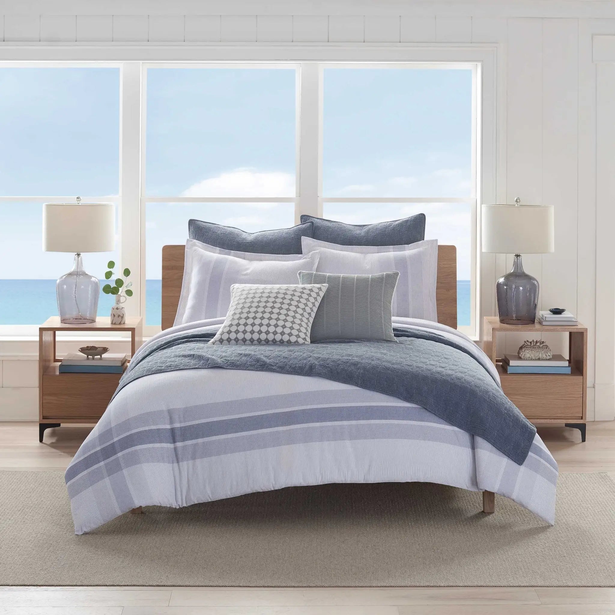Bedroom with a neatly made bed featuring striped bedding and pillows.
