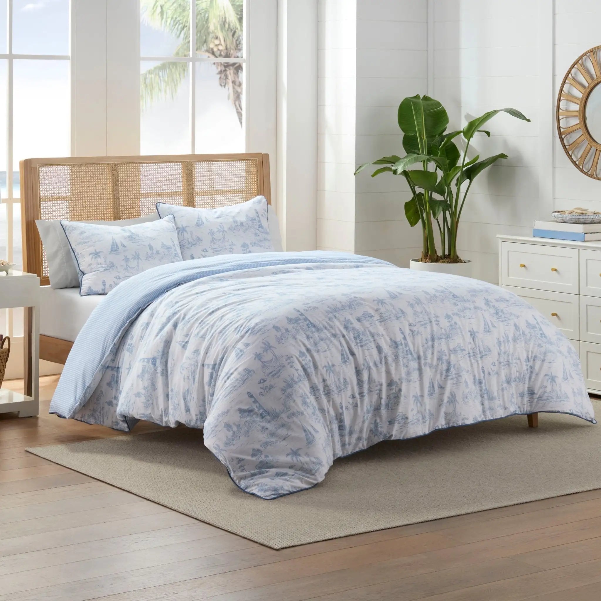 A light blue and white tropical print comforter set.