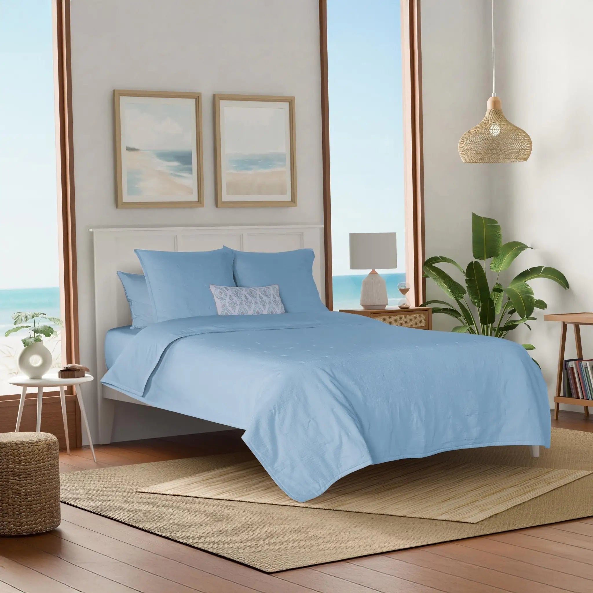 Bedroom with light blue quilt and euros.