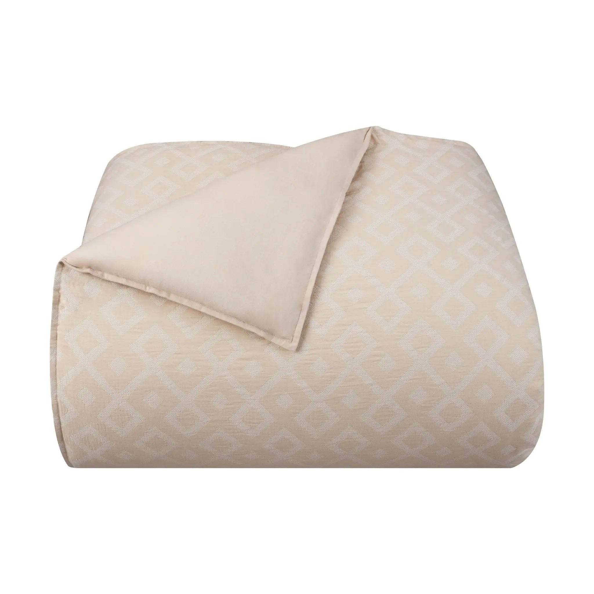 A folded beige quilted comforter with a subtle geometric diamond pattern, showing a smooth solid beige reverse side, set against a plain white background.