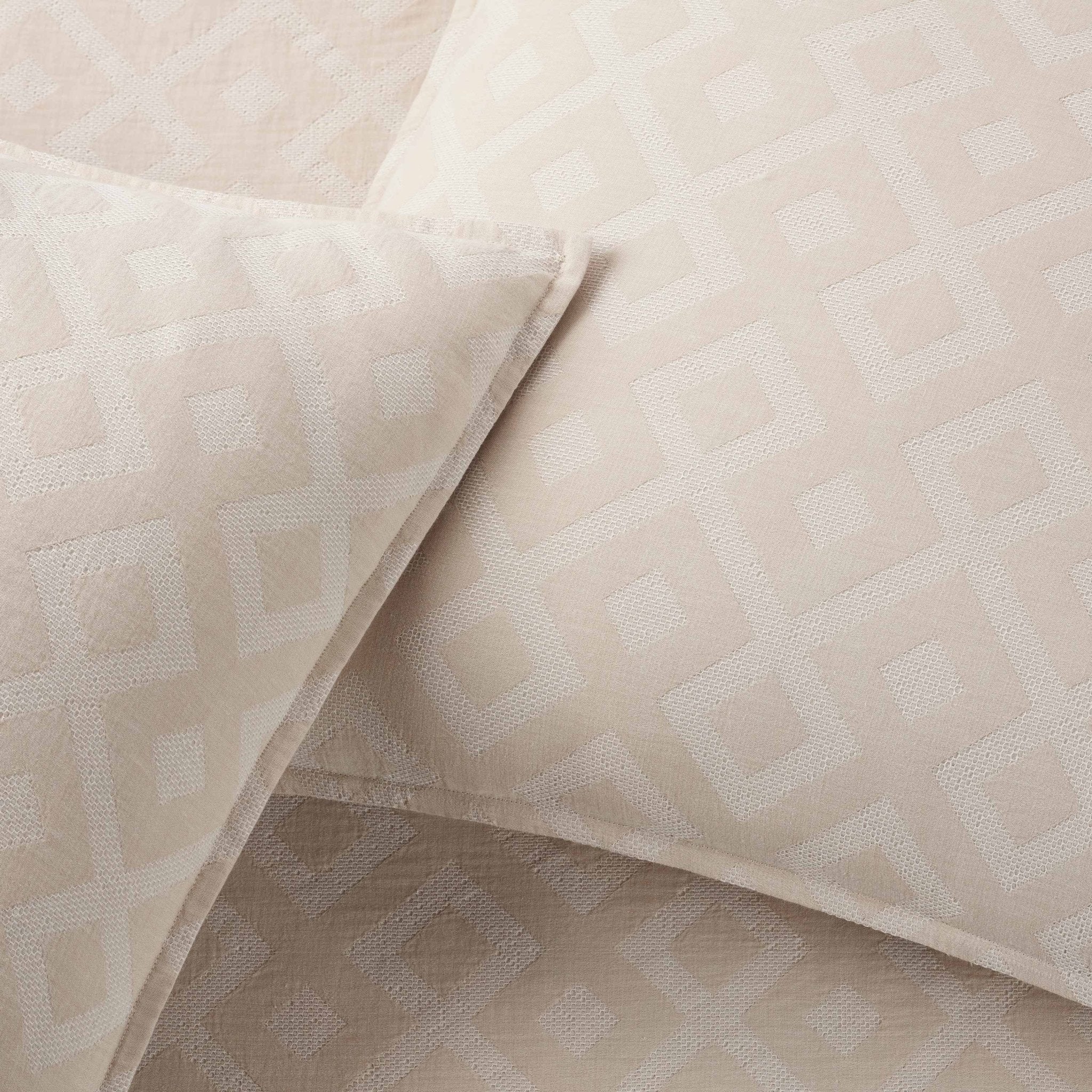 Close-up of beige textured fabric with geometric pattern