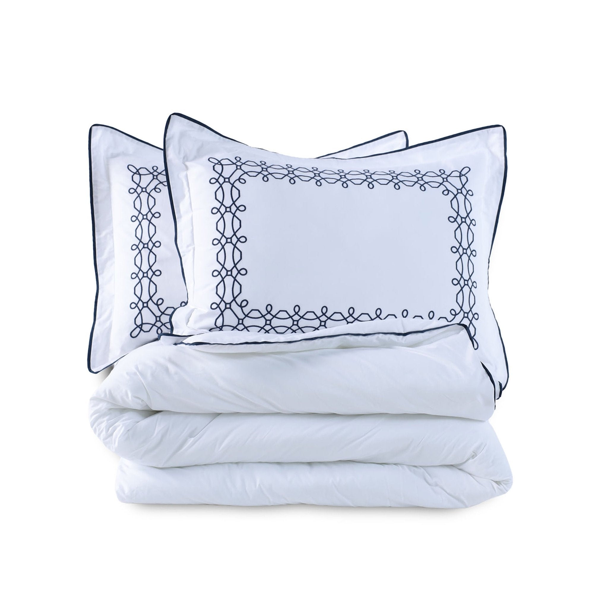 White comforter set with embroidered shams on a white background