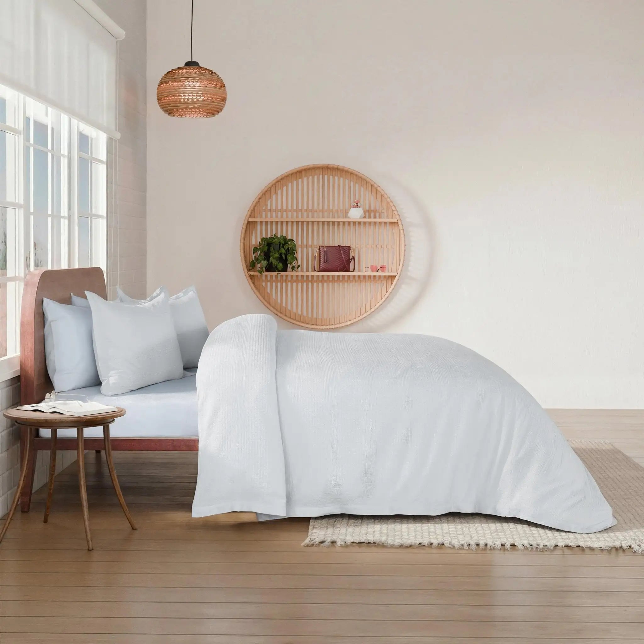Bedroom with a bed covered in white comforter set.