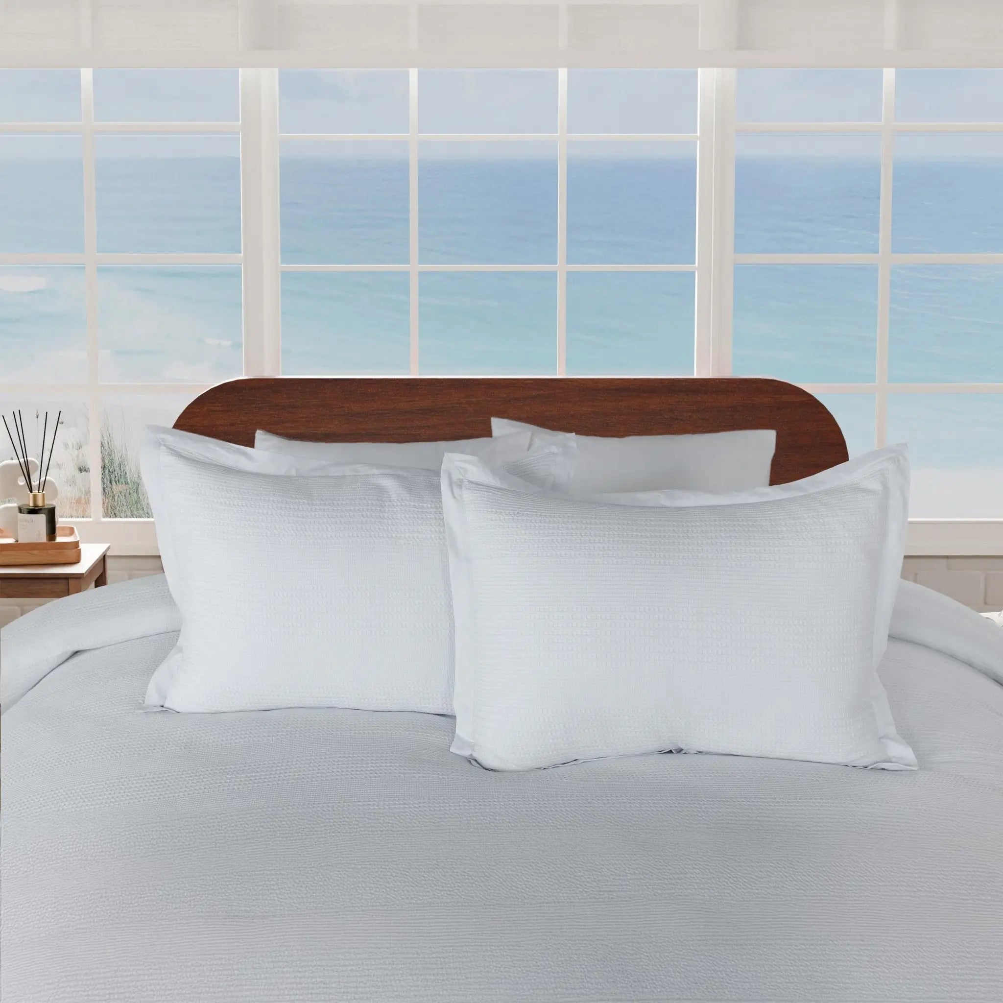 Two grey textured pillow shams displayed on a bed.
