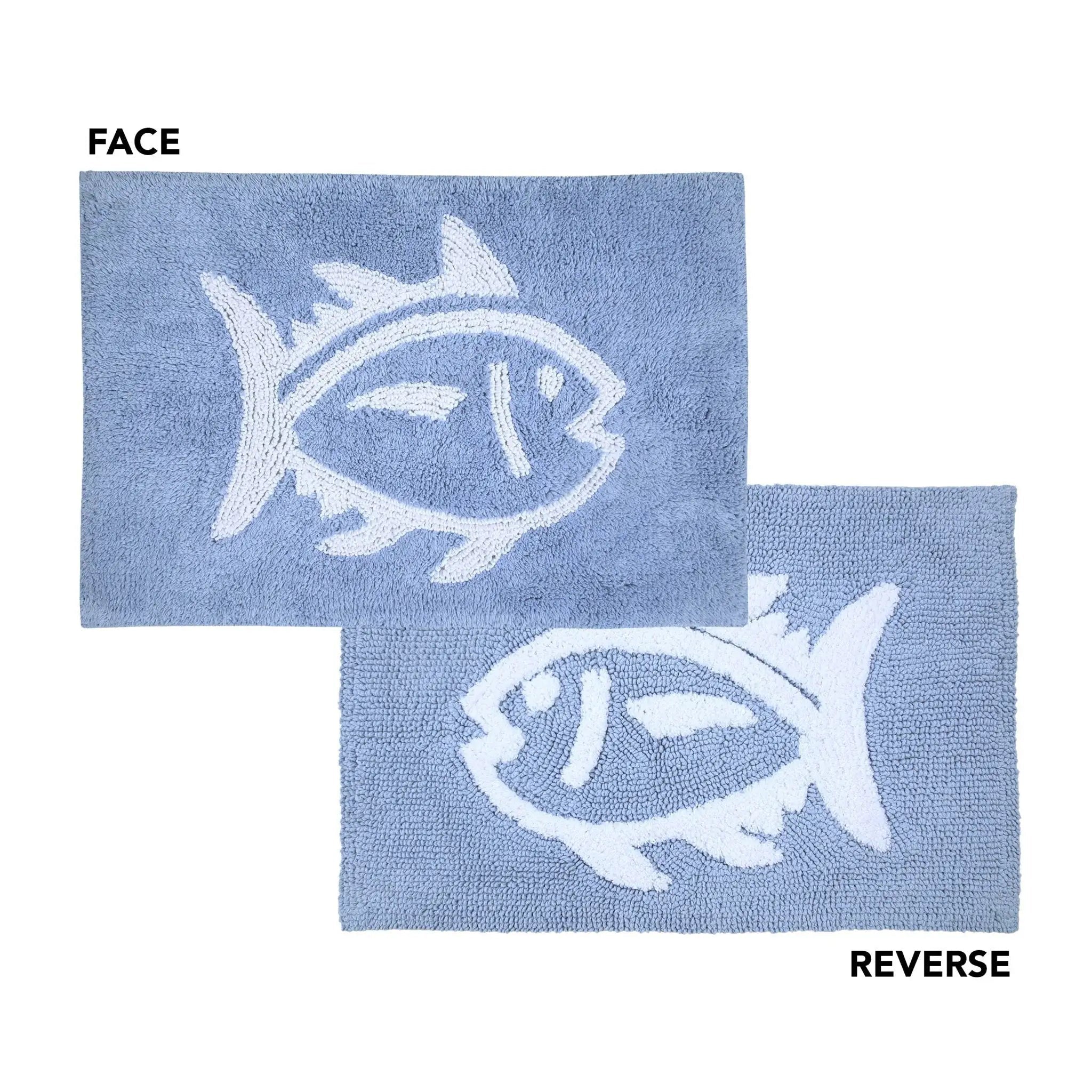 Two light blue bath rugs shown on a white background, labeled FACE and REVERSE. Each rug features a large white fish motif, with the top mat showing the raised fish from one side and the bottom mat showing the reverse side.