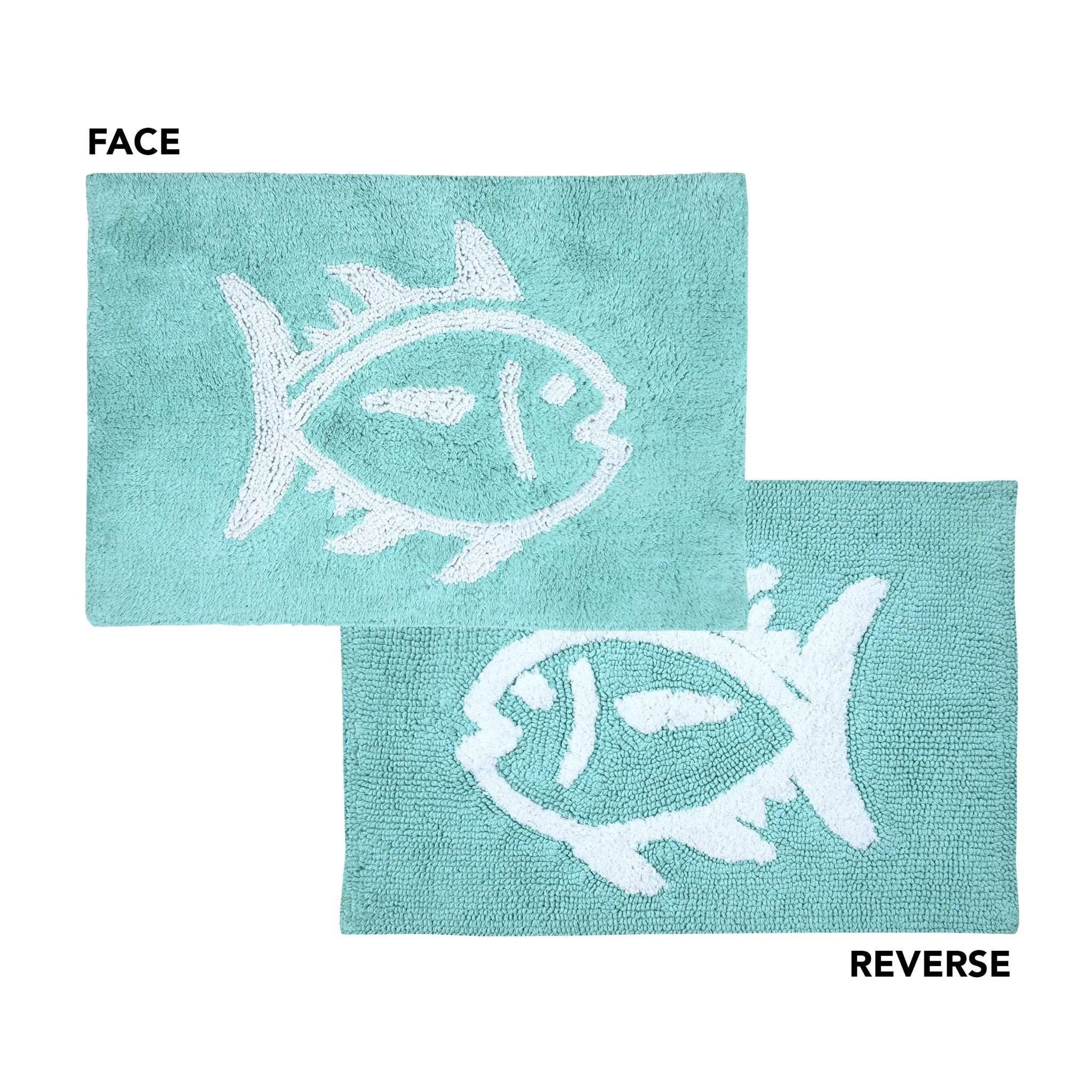 Two aqua bath rugs with white fish motifs, labeled FACE and REVERSE to show the textured reverse side, on a white background.