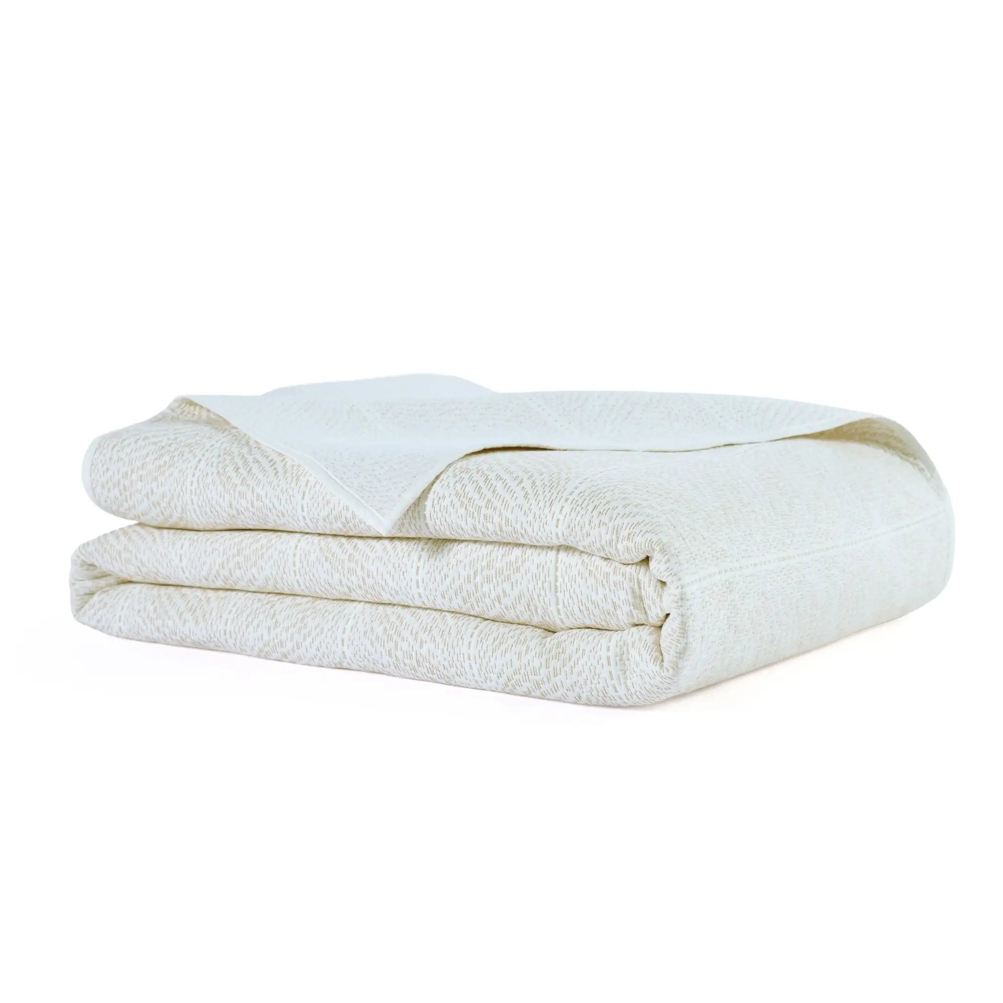 A folded white textured quilt with a subtle woven pattern, shown on a clean white background.