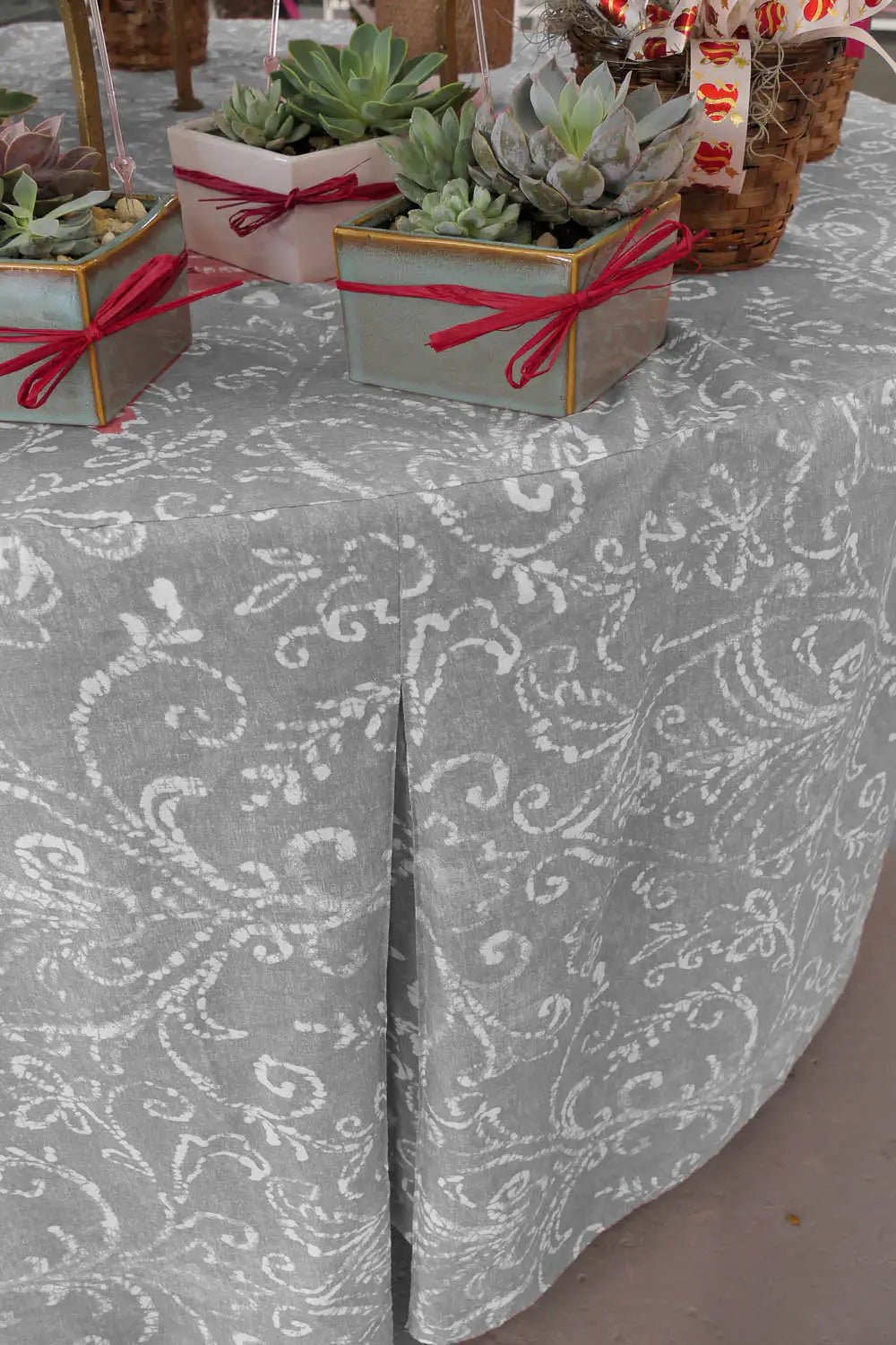 Decorative grey tablecloth with paisley pattern on a table.