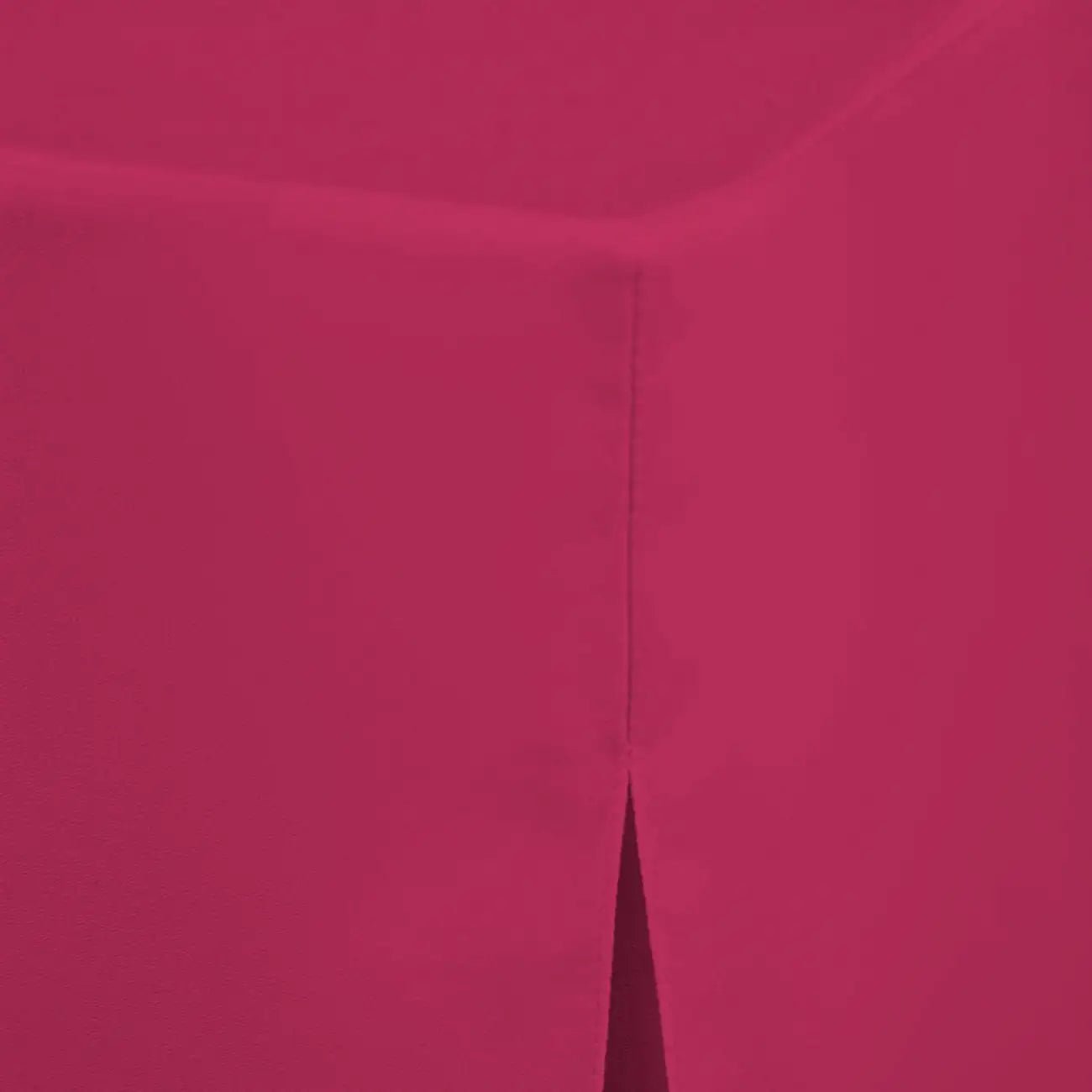 A close-up of a solid fuchsia colored material with a subtle texture and a vertical seam running down the center.