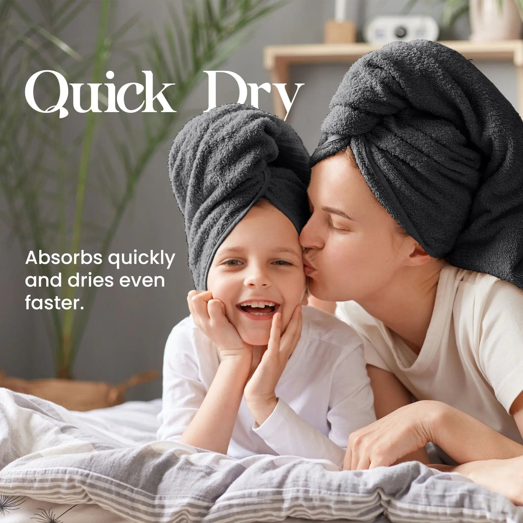 Woman and a child with black towels on their heads lying on a bed, with text about quick dry towels.