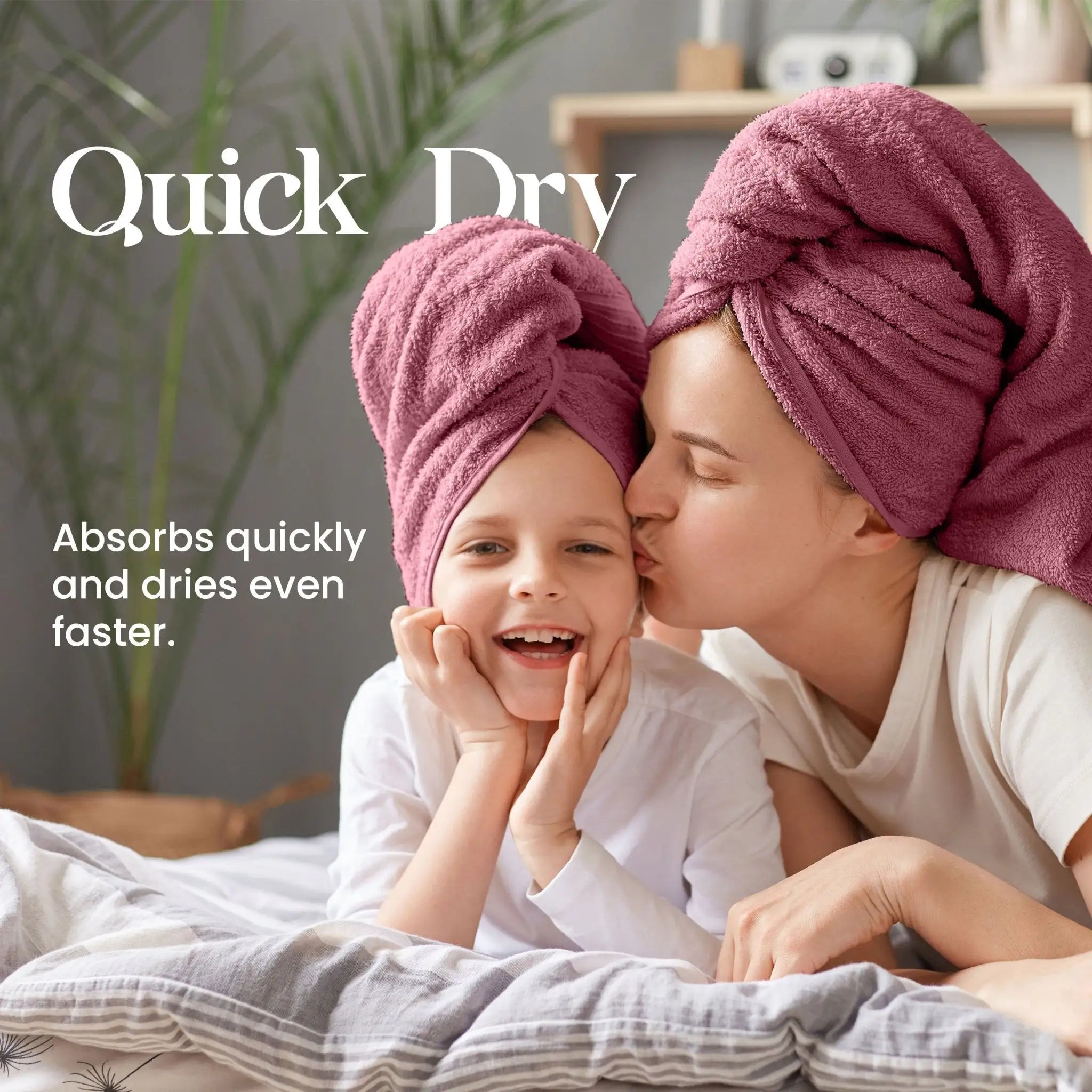 A woman and a child wearing soft red towel on their heads, smiling and kissing, with the text 'Quick Dry' and 'Absorbs quickly and dries even faster.' on a bedroom background.