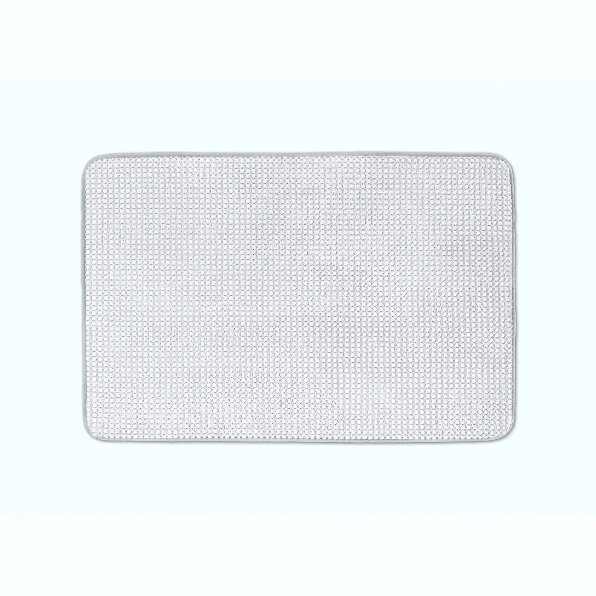 A rectangular light grey bath rug, shown flat against a very light blue background.