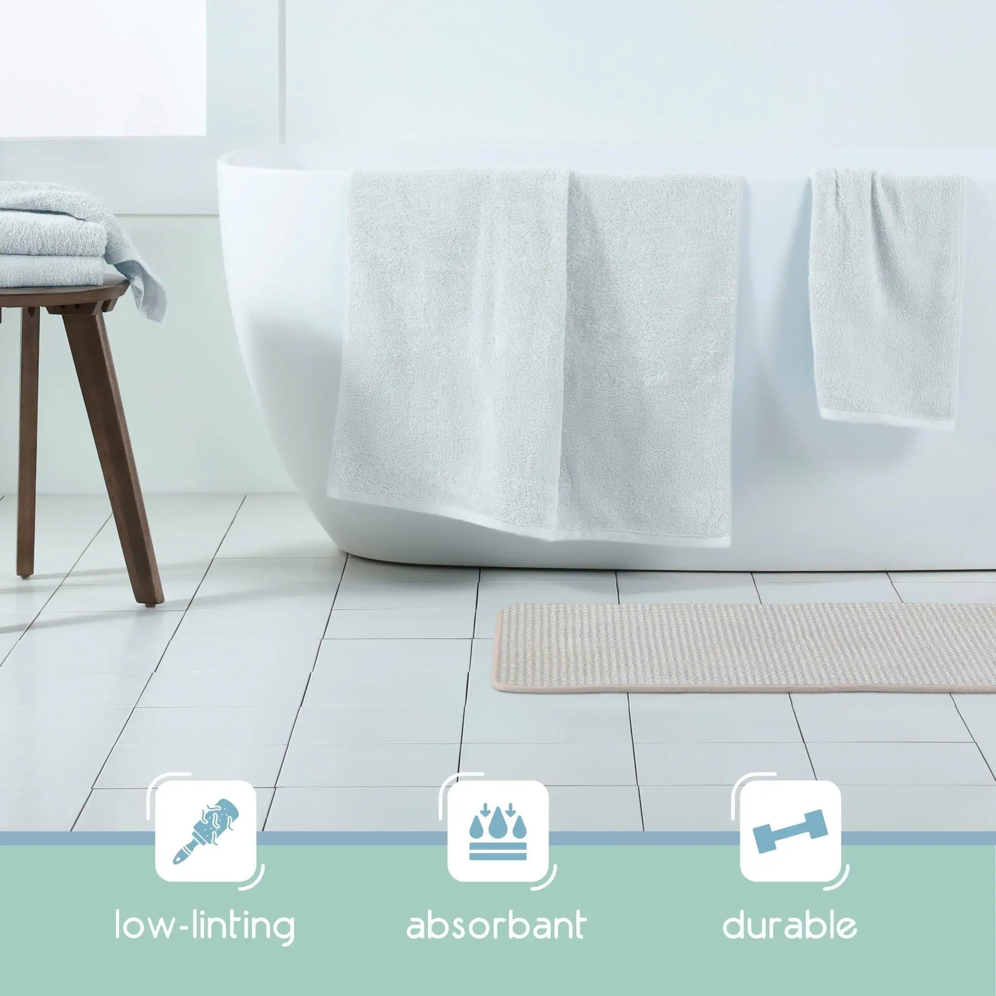 Sand color bath rug on the floor and three feature icons at the bottom reading low-linting, absorbant, and durable.
