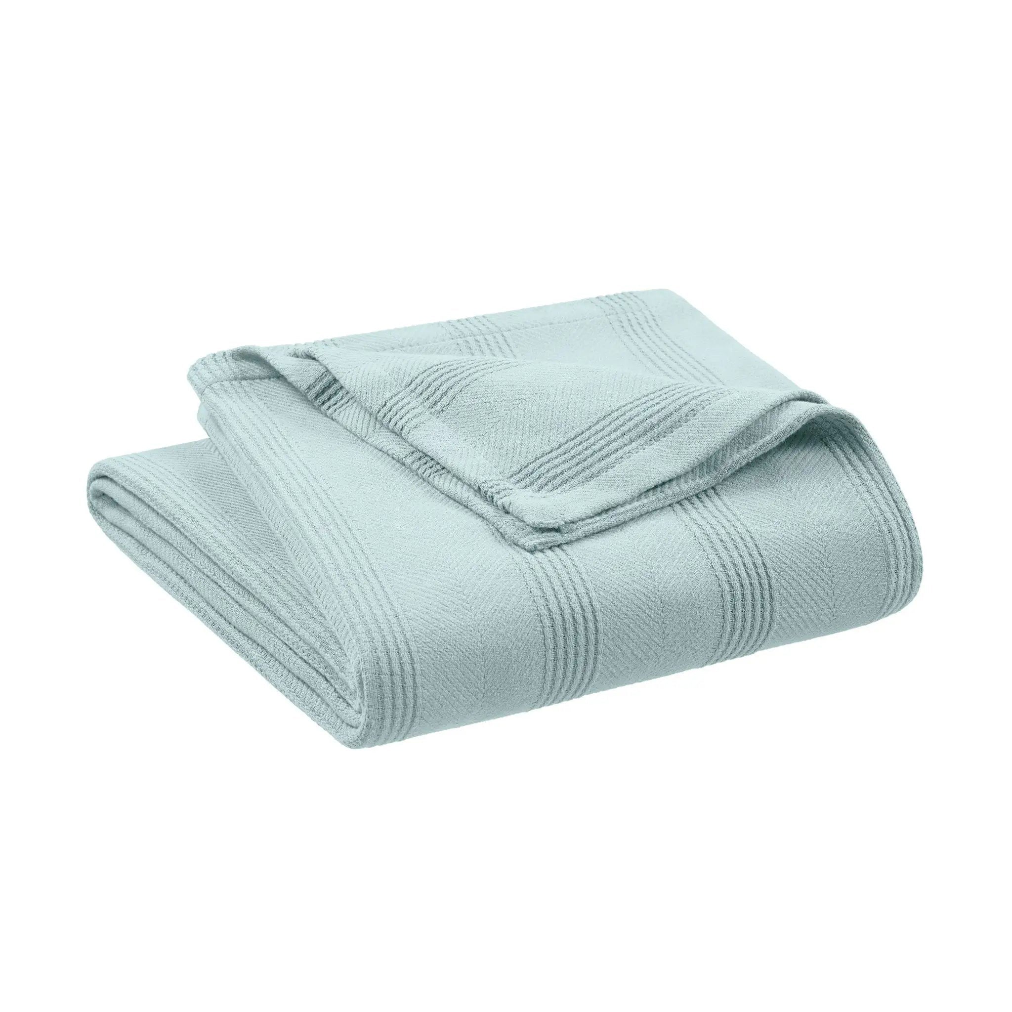 Folded light blue blanket on a white background