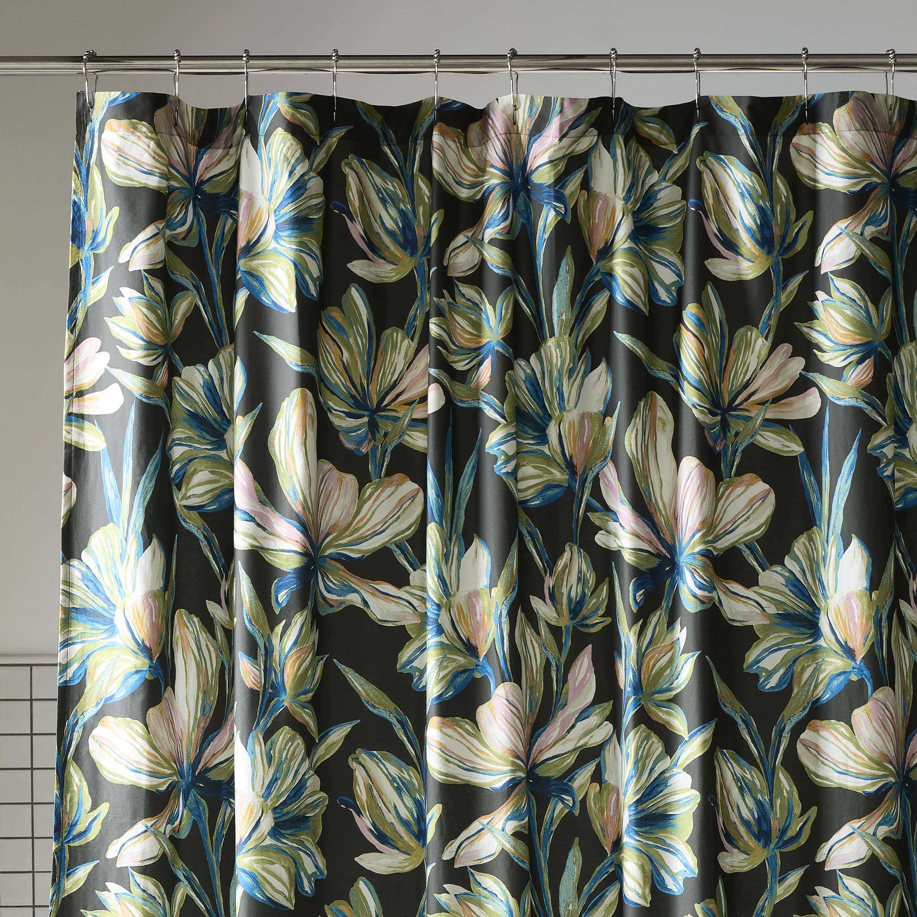 Floral shower curtain featuring large, colorful flowers on a dark background, with metal grommets for hanging.