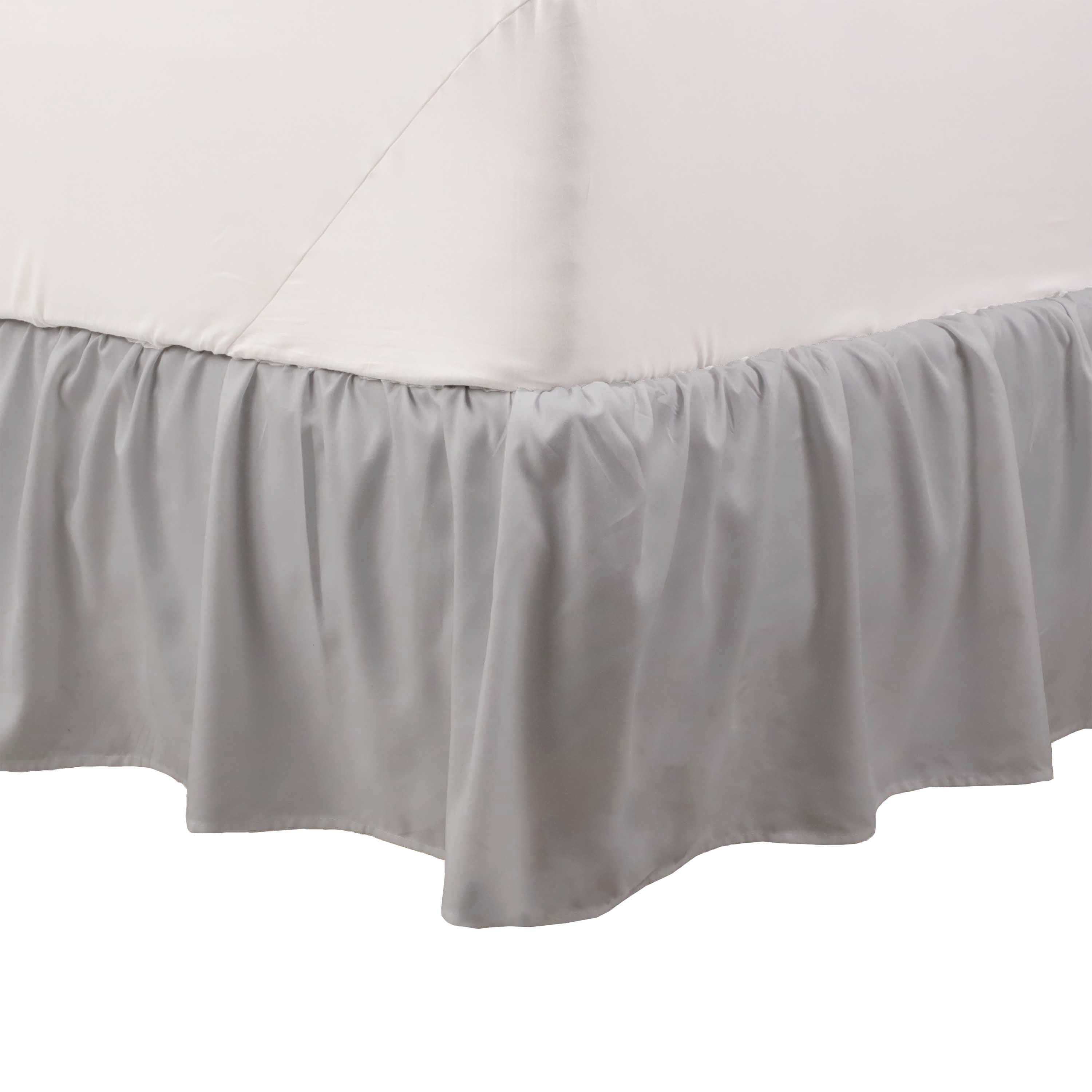 Gray ruffle bed skirt drapes elegantly along the bottom of a bed, covering the box spring.