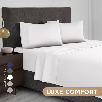 White Supima cotton sheet set on a bed with gray headboard and nightstand, featuring available color swatches.