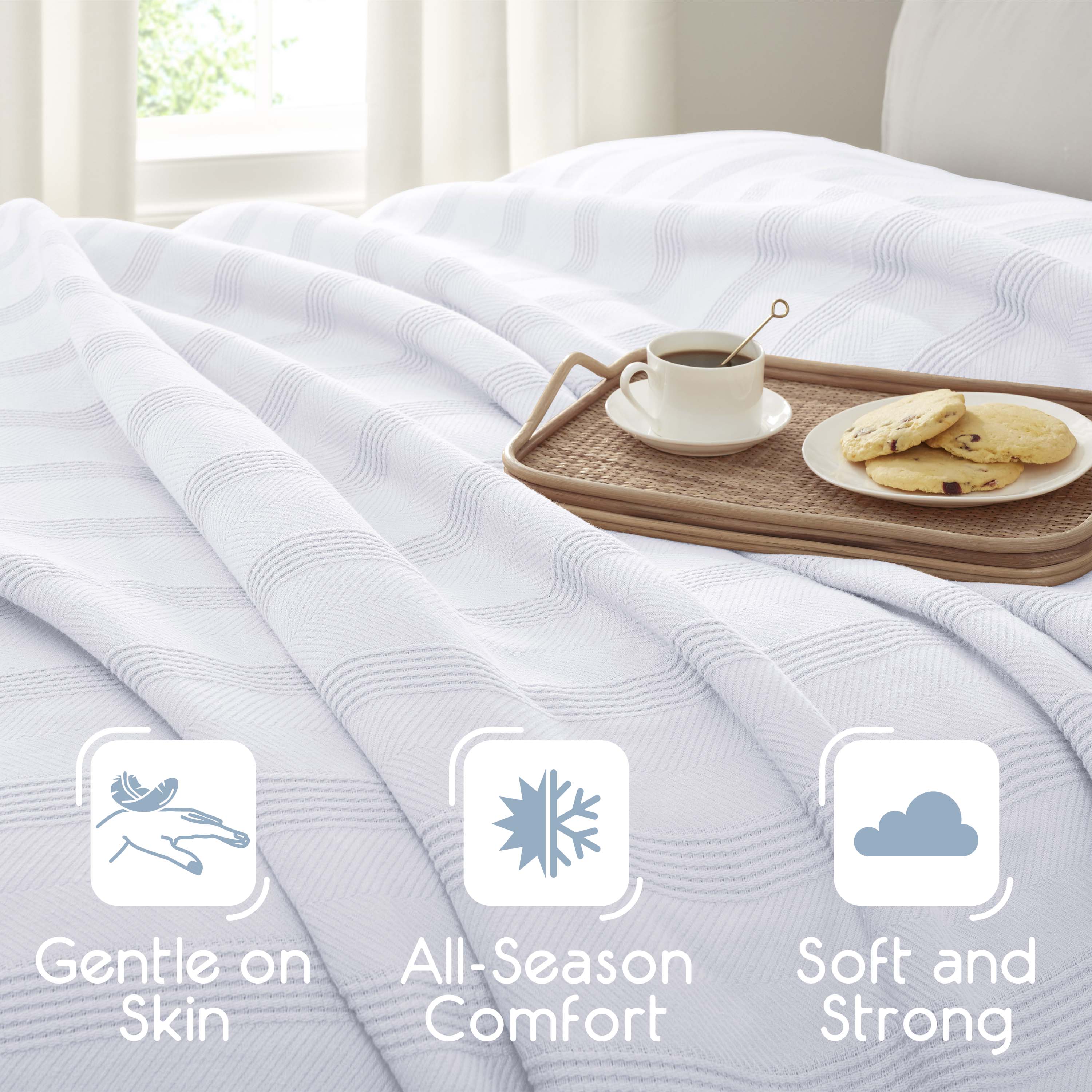 Cotton blanket with a textured pattern, draped over a bed, alongside a tray with coffee and cookies.