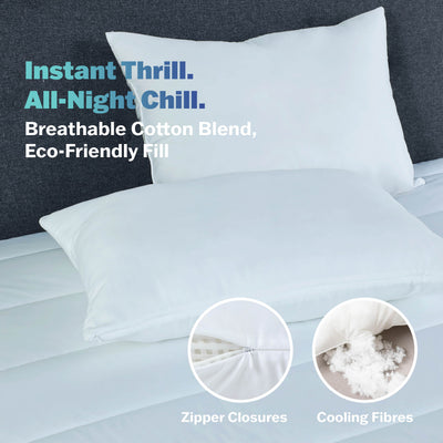 White bed pillows on a mattress, featuring zipper closures and cooling fibers.