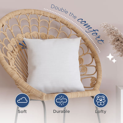 White decorative pillow resting on a rattan chair with a soft texture and a simple design.